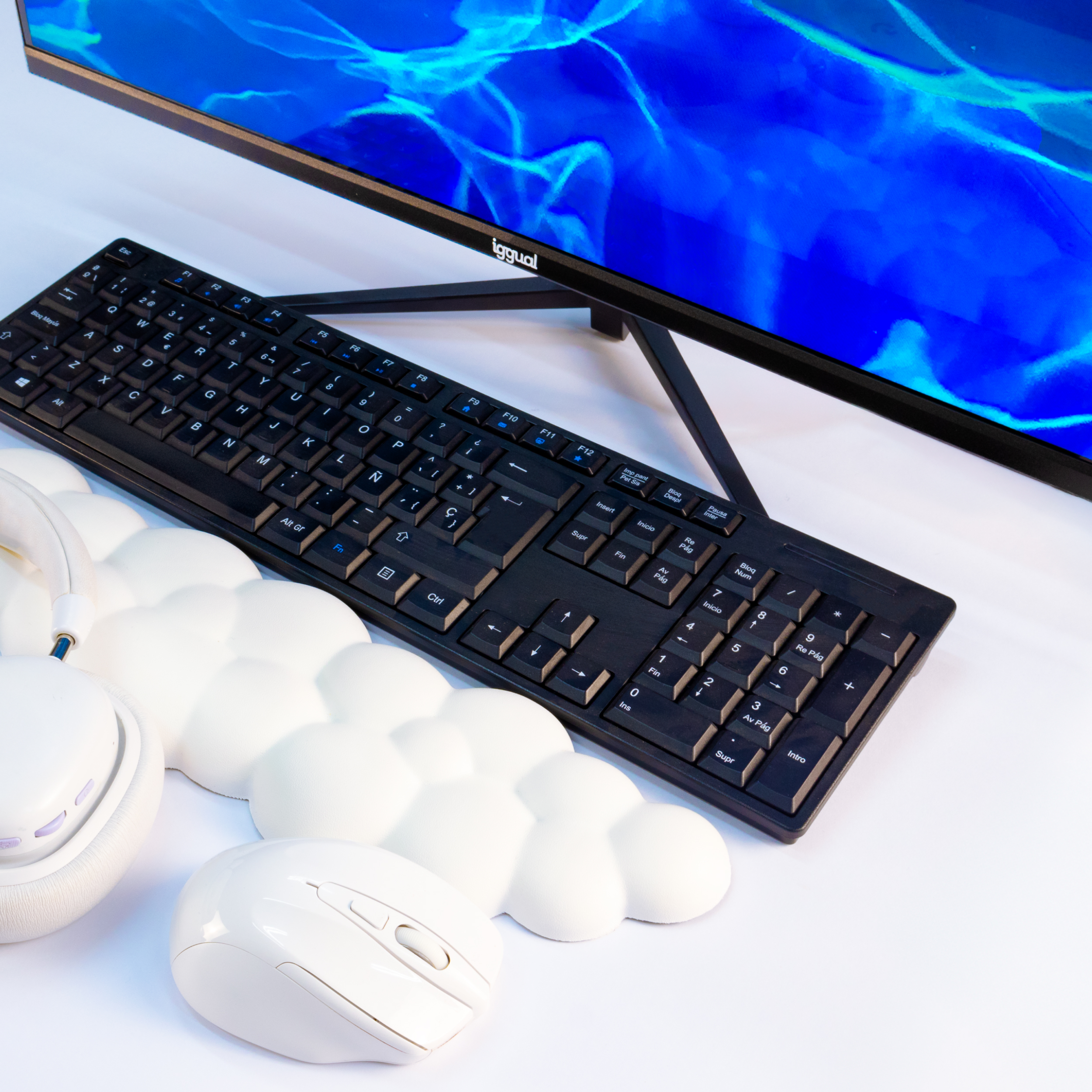 Tastiera nera, mouse bianco, poggiapolsi a forma di nuvola, cuffie bianche, monitor blu.