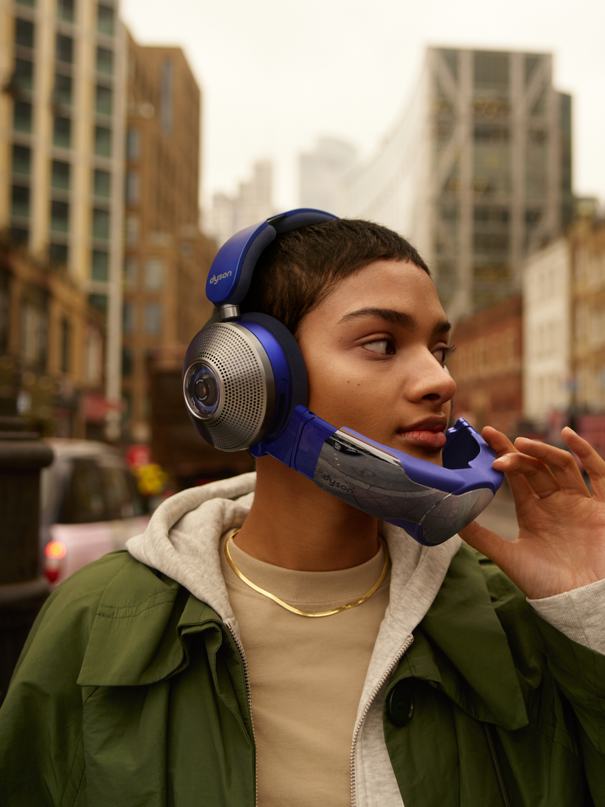 Kobieta w niebieskich słuchawkach i masce na twarzy w mieście.