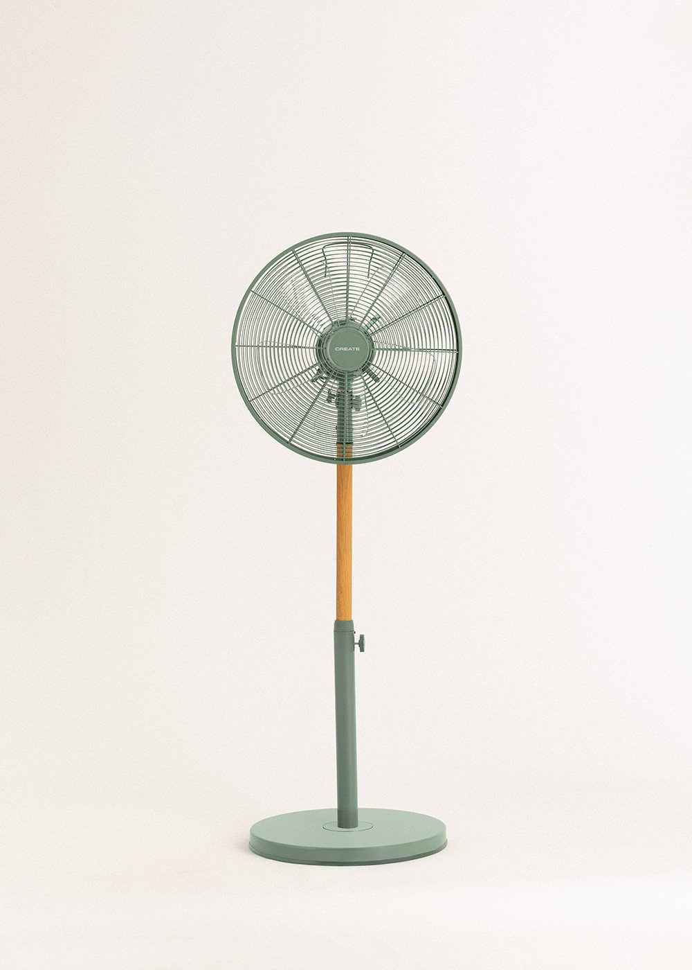 Un ventilador de pie verde con un poste de madera sobre un fondo blanco.