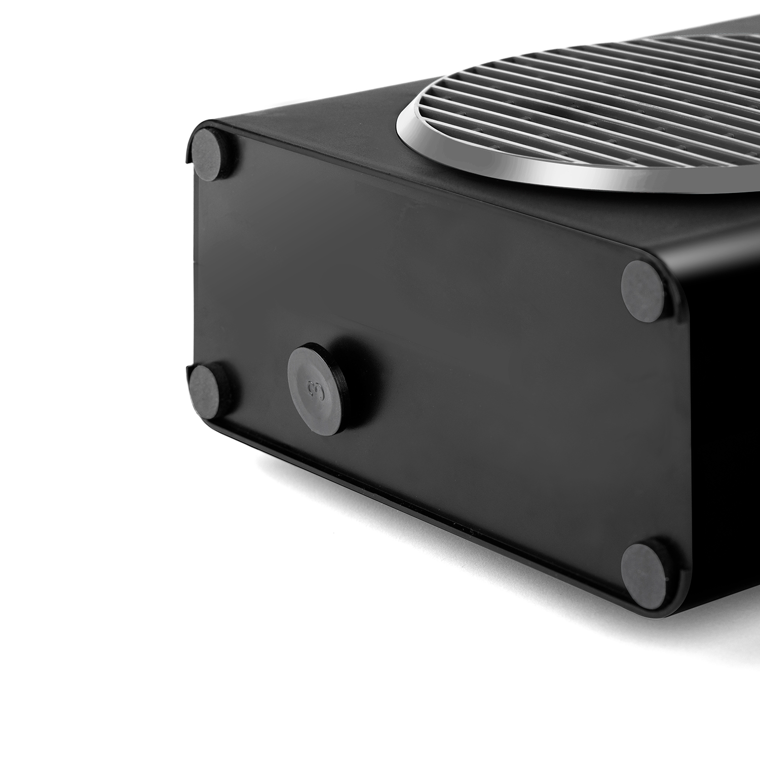 Czarny prostokątny grzejnik ze srebrną kratką. Widoczne cztery gumowe nóżki. Białe tło.