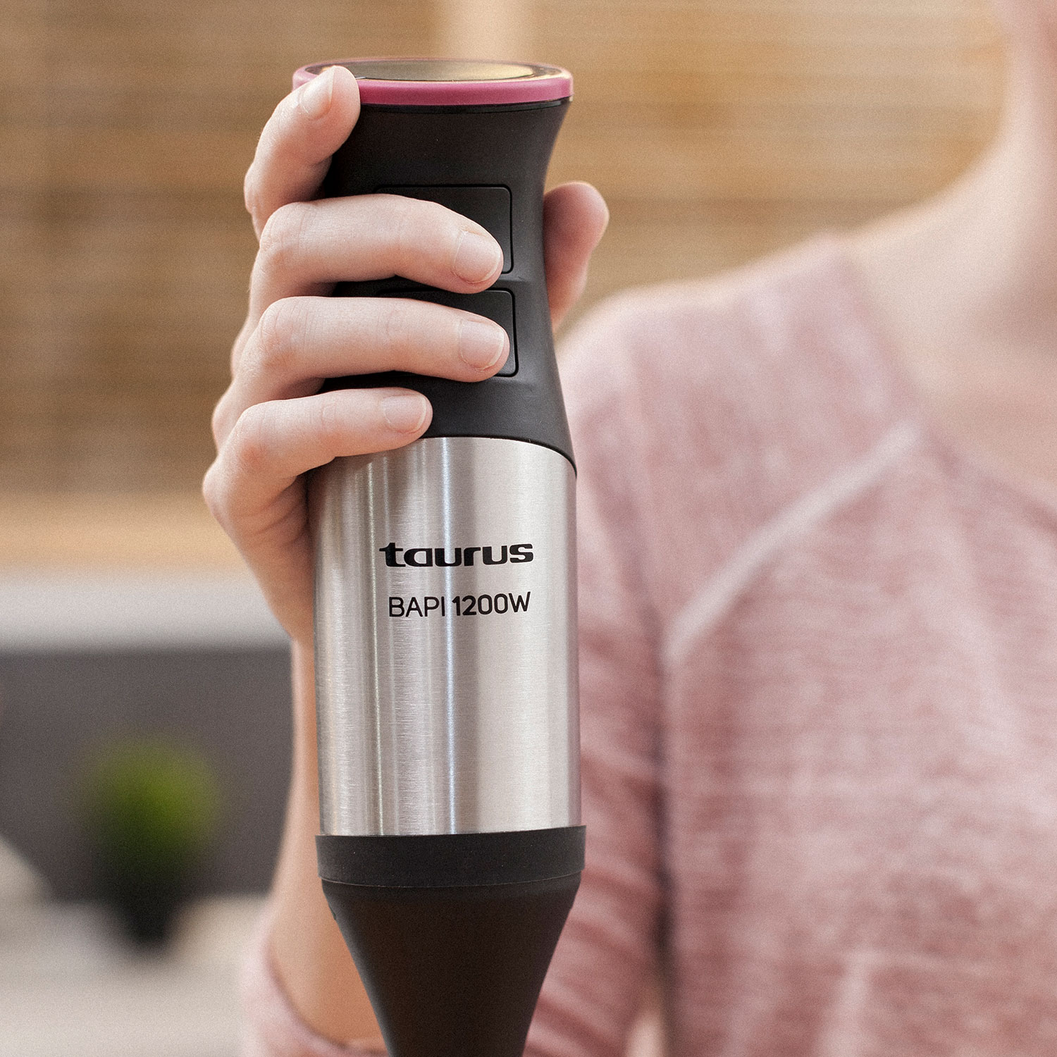 Ręka trzymająca srebrno-czarny blender ręczny Taurus z dwoma przyciskami.