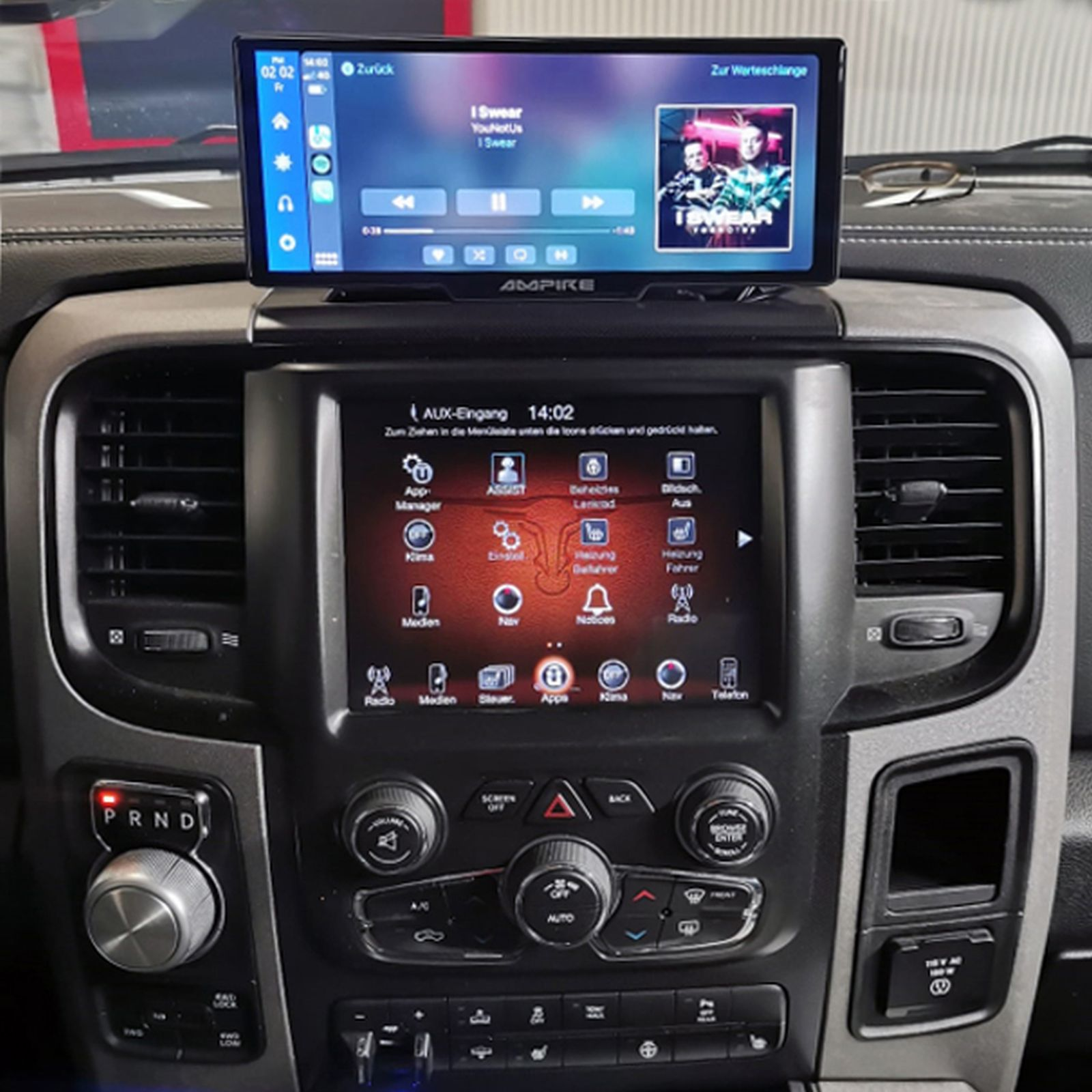 Armaturenbrett eines Autos mit einem oberen Bildschirm, der Musikbedienelemente anzeigt, und einem Touchscreen-Display darunter.