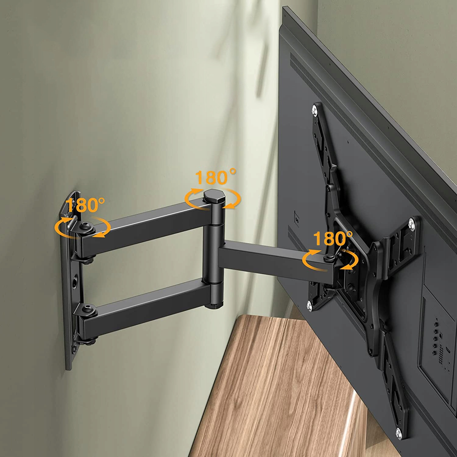 Czarny uchwyt ścienny do TV, z obrotem 180 stopni, zamontowany na zielonej ścianie. Widoczny jest również telewizor i drewniany stół.