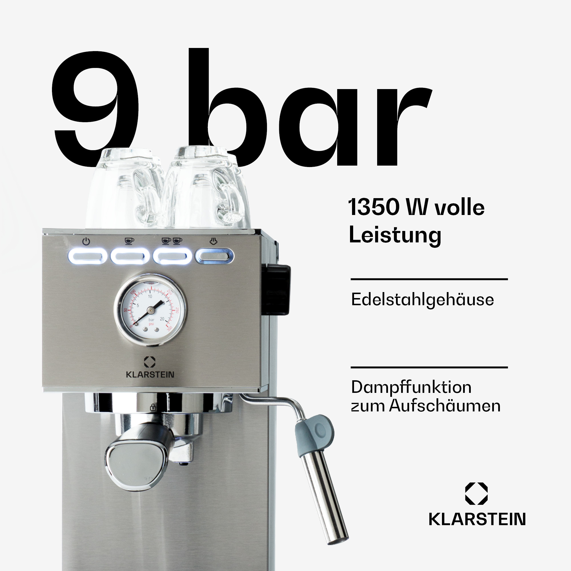 Cafetera espresso plateada con medidor, dos tazas de cristal, lanza de vapor, fondo blanco.
