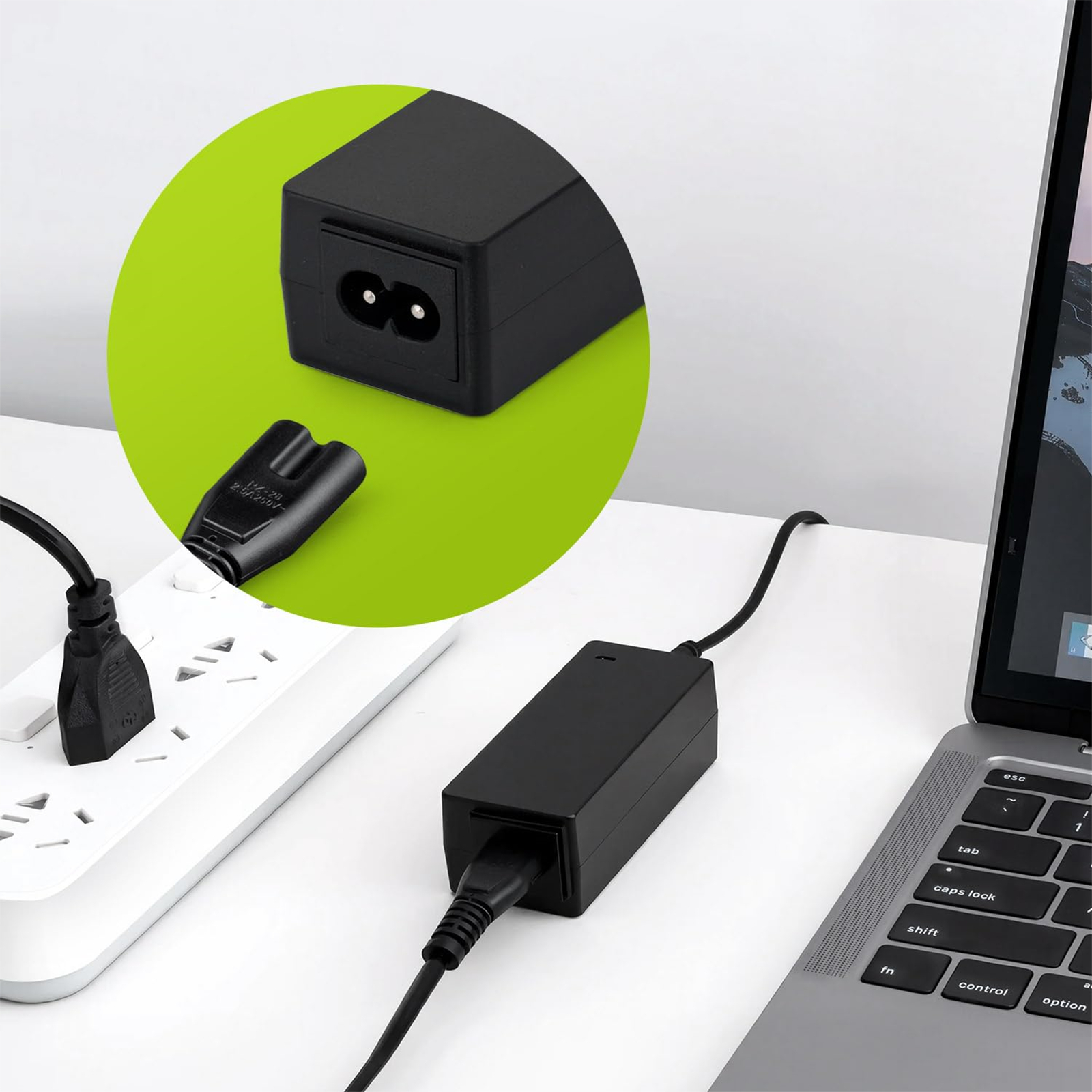 Ein AC-Netzteil ist an einen Laptop und eine Steckdose angeschlossen. Der Adapter ist schwarz.