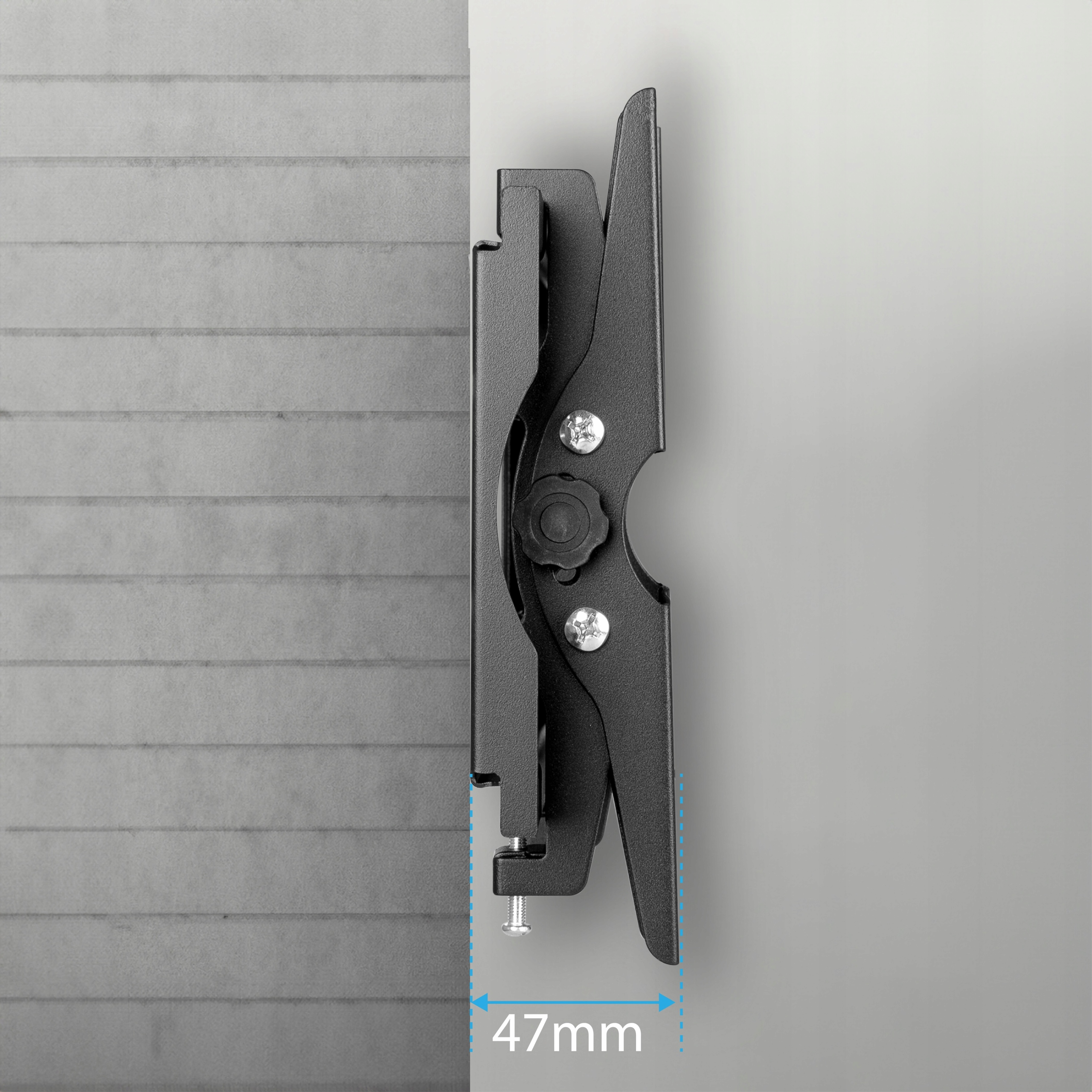 Czarny uchwyt TV jest przymocowany do szarej ściany. Uchwyt jest ustawiony pod kątem i pokazuje, jak bardzo wystaje.