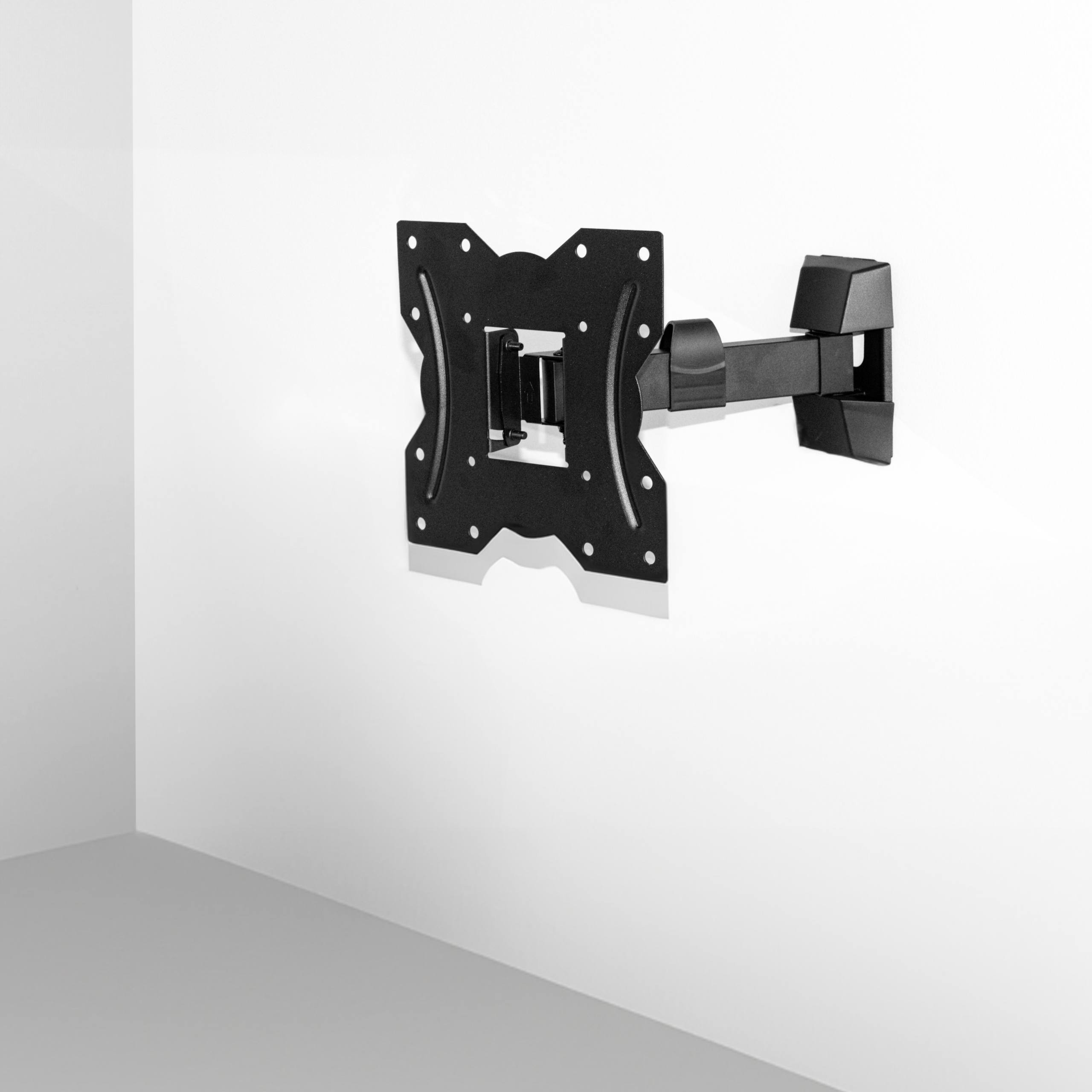 Czarny uchwyt TV jest przymocowany do białej ściany. Uchwyt ma ramię obrotowe. Biała ściana.
