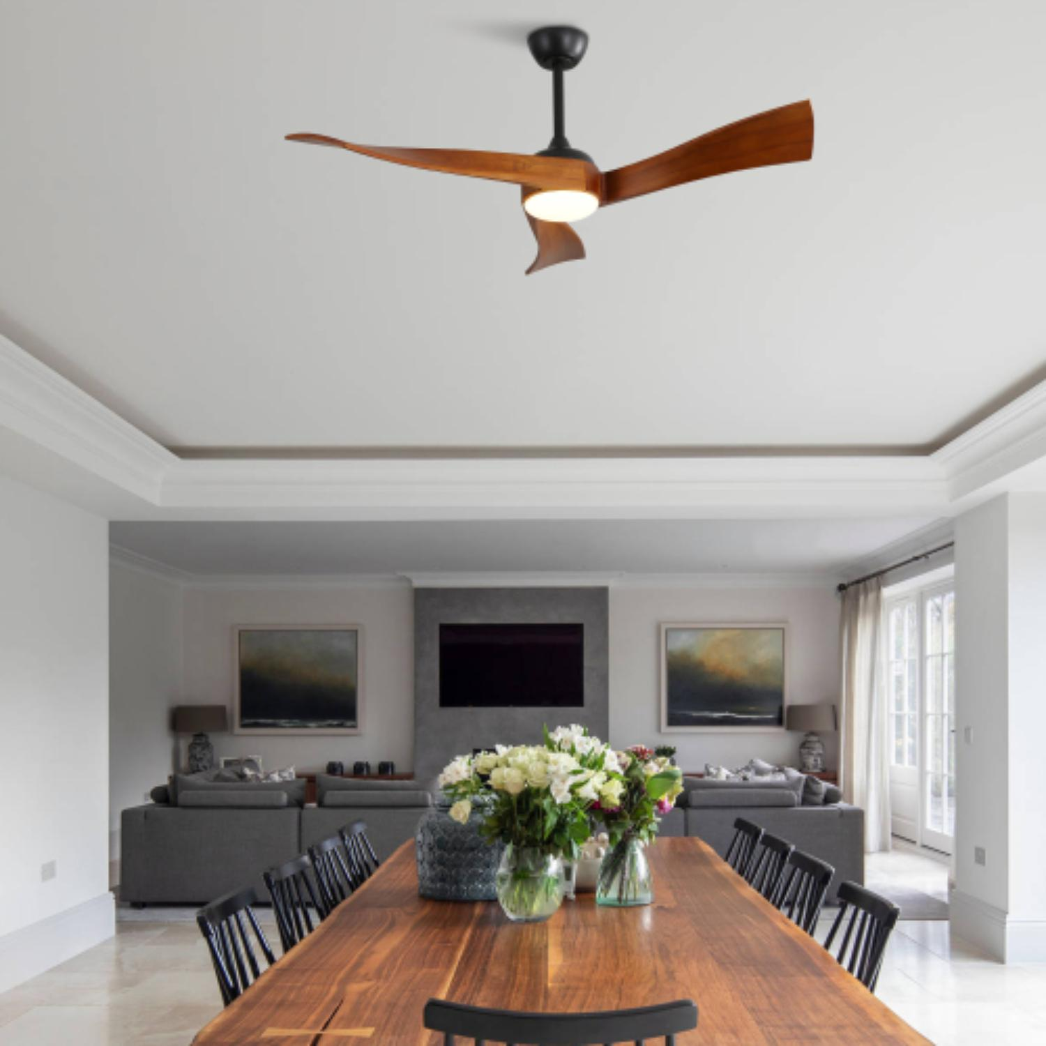 Esszimmer mit Deckenventilator, langem Holztisch, Stühlen und großem Fenster. Neutrale Farben.