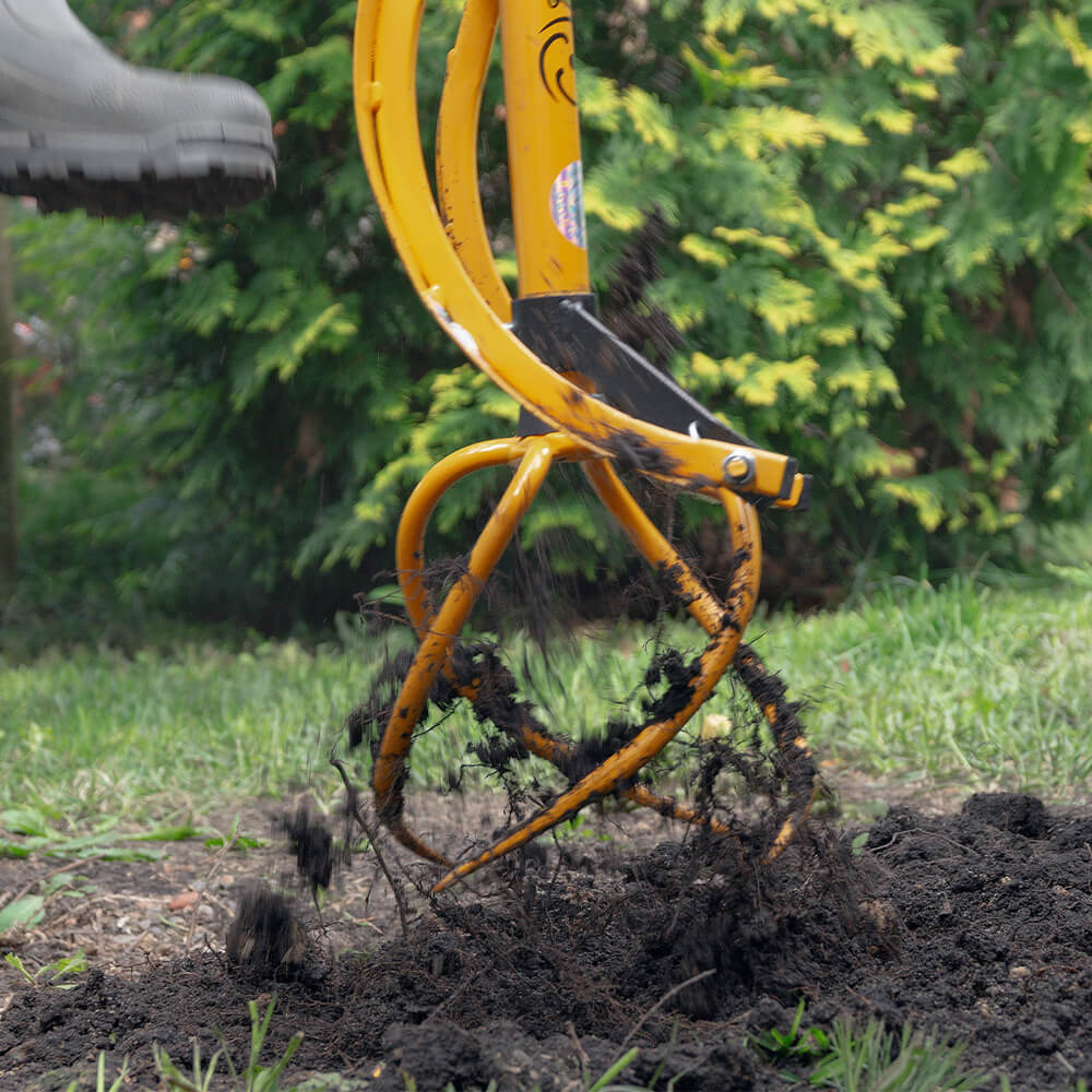 Gartengerät in Gebrauch, Unkraut aus dem Boden entfernend.