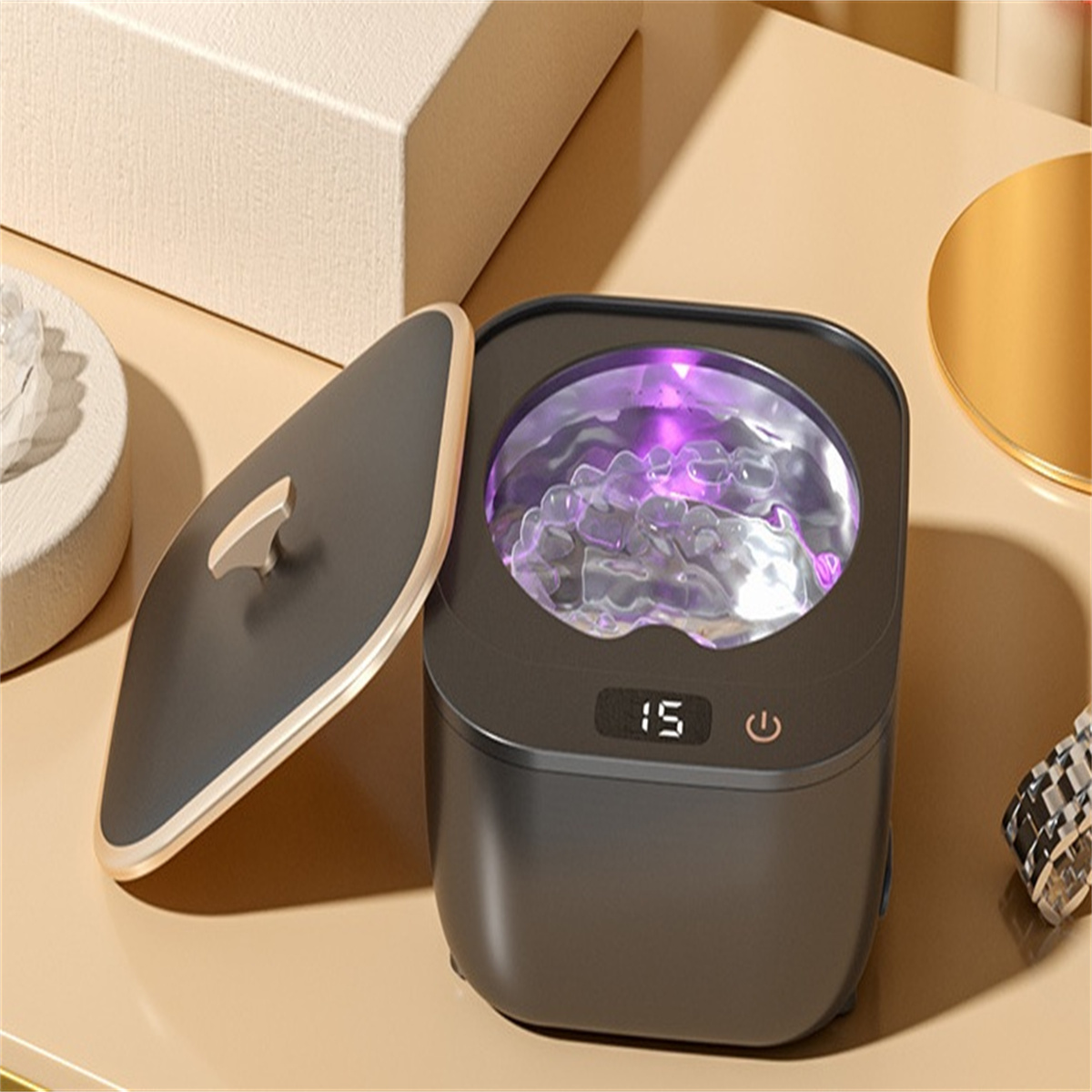Schwarzer UV-Sterilisator mit geöffnetem Deckel, Innenraum mit lila Licht.