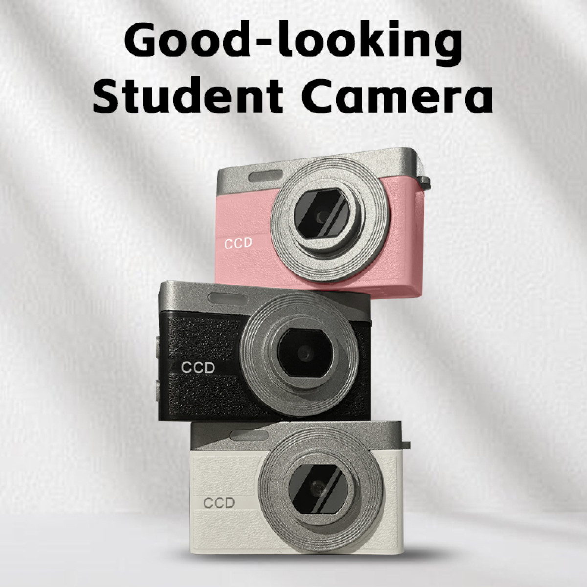 Drie kleine speelgoedcamera's gestapeld; roze, zwart en wit, met 'CCD'.