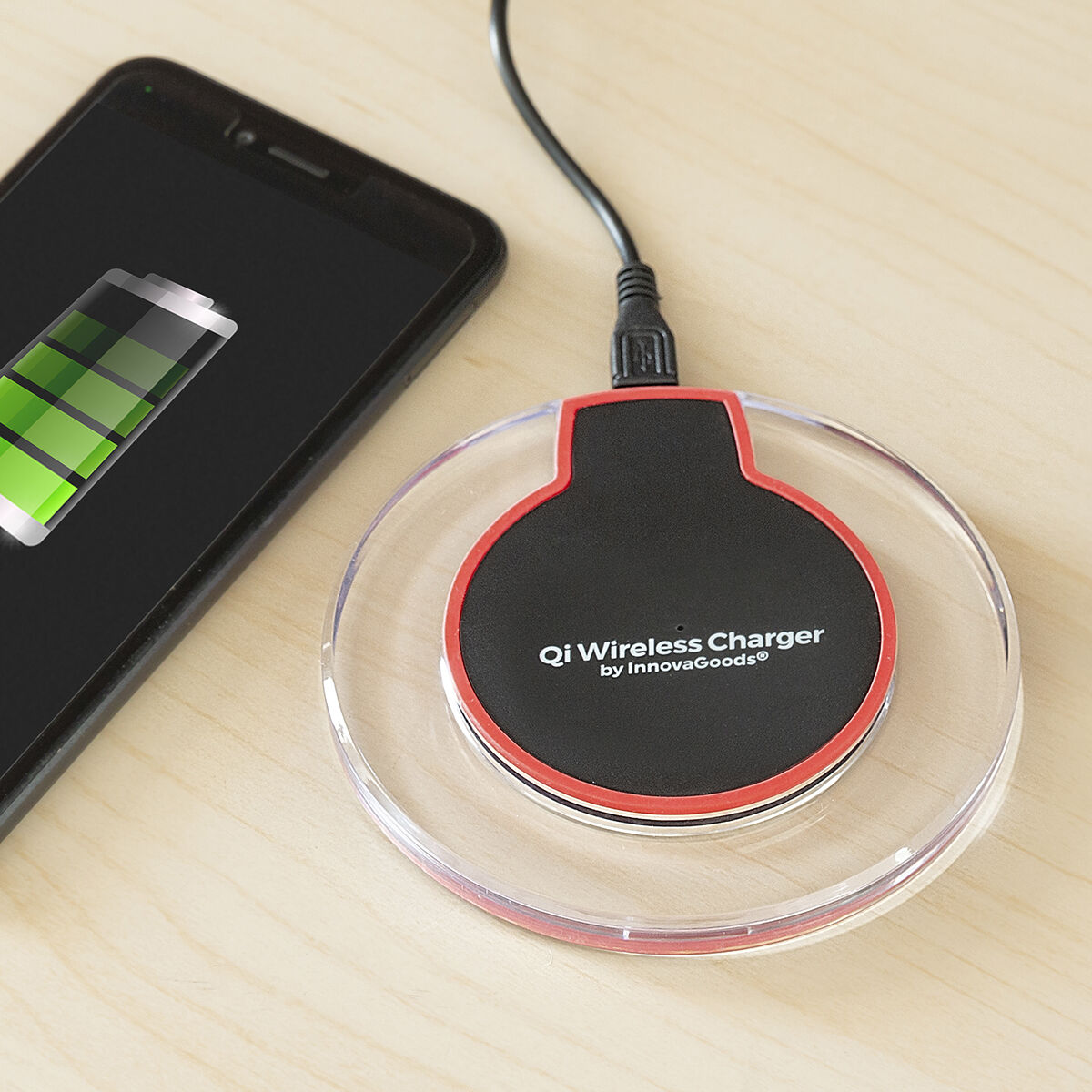 Schwarzes Smartphone, das auf einem kabellosen Ladegerät geladen wird.