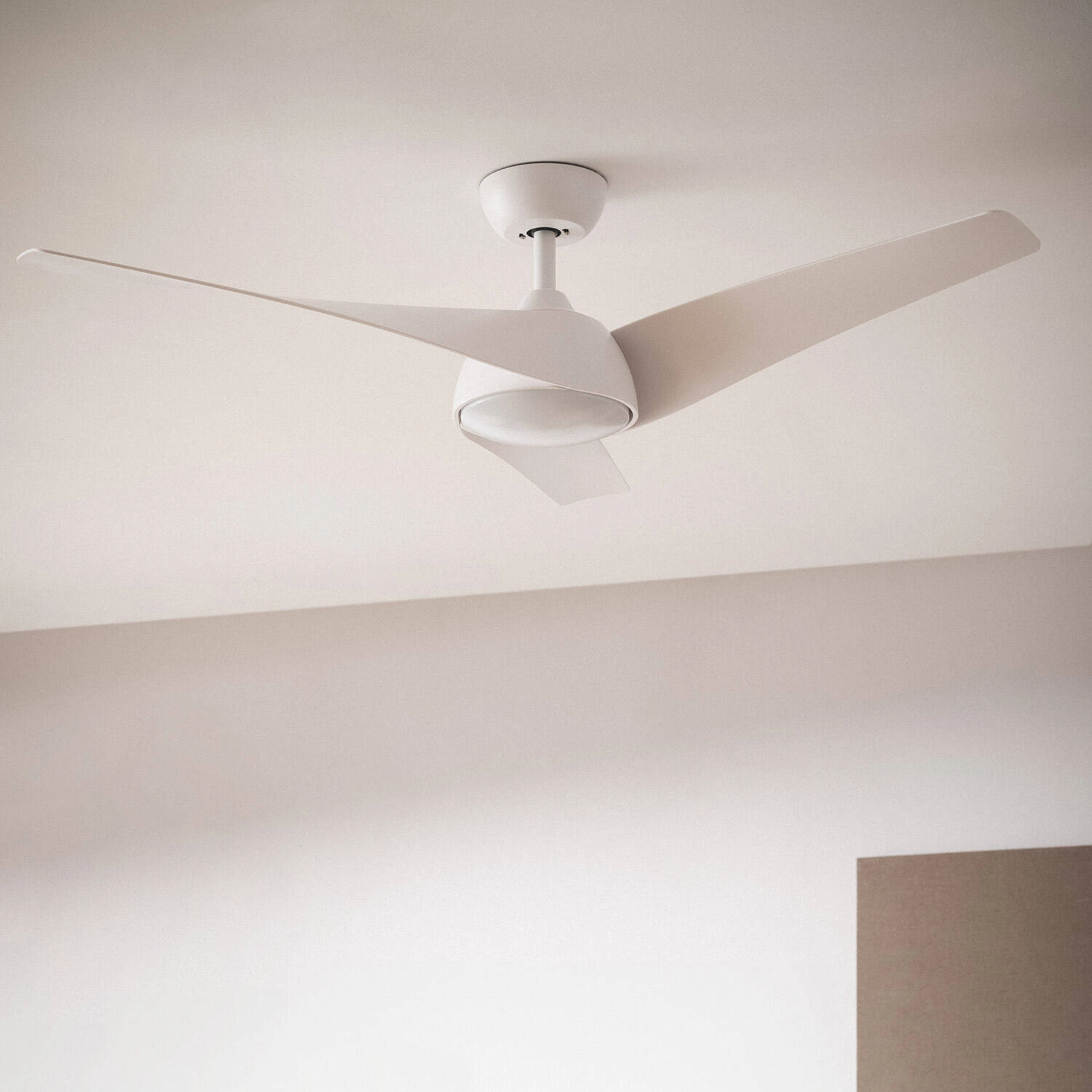 Ventilatore da soffitto bianco con tre pale. Le pale sono angolate. Lo sfondo è bianco.