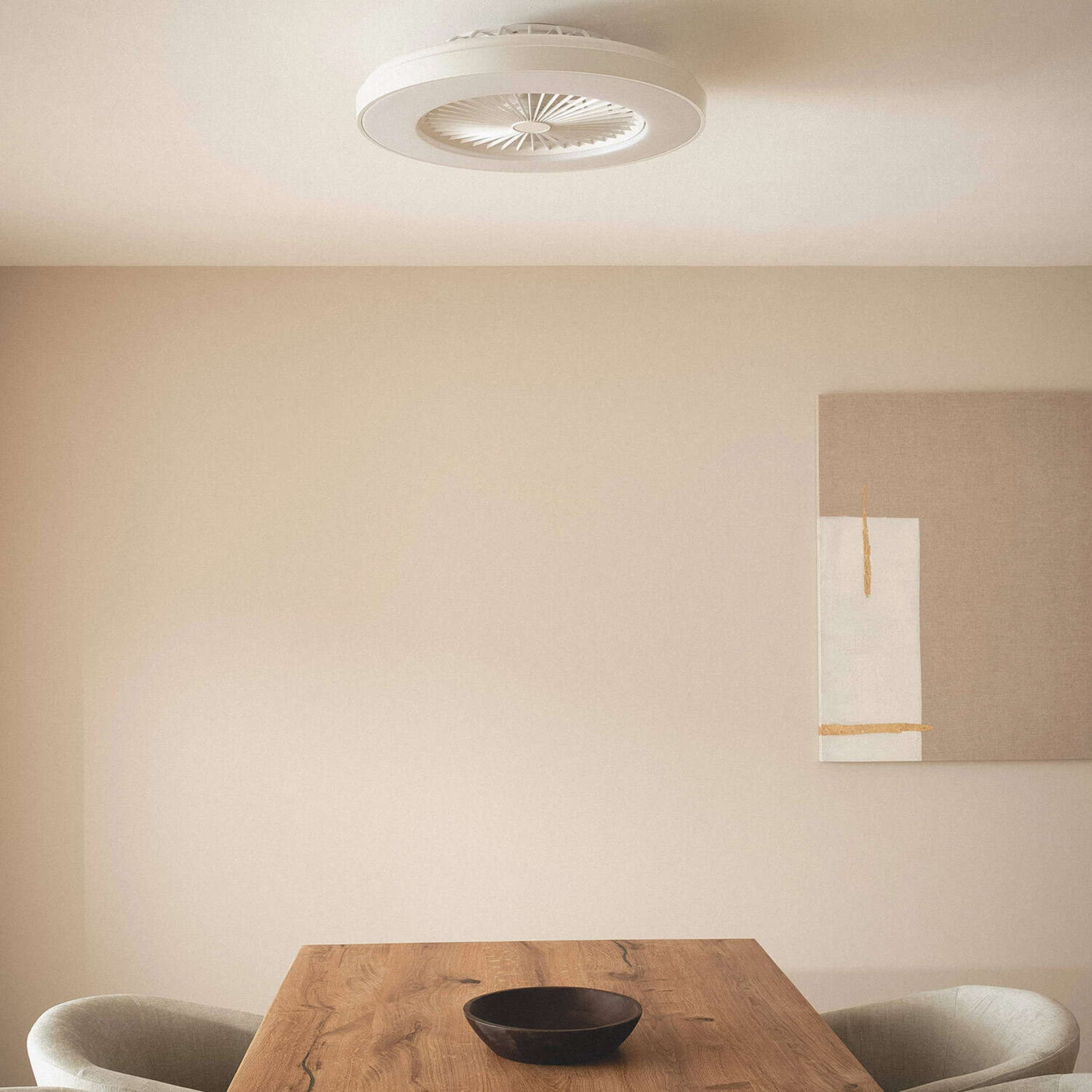 Ventilatore da soffitto con luce, montato sul soffitto. Interno dai colori neutri.