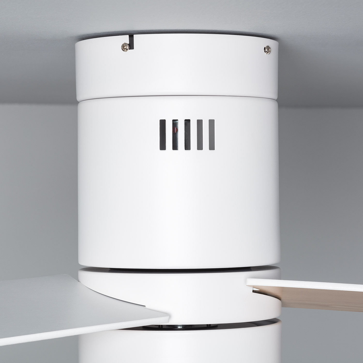Primo piano dell'alloggiamento del motore del ventilatore da soffitto bianco. Lo sfondo è grigio.
