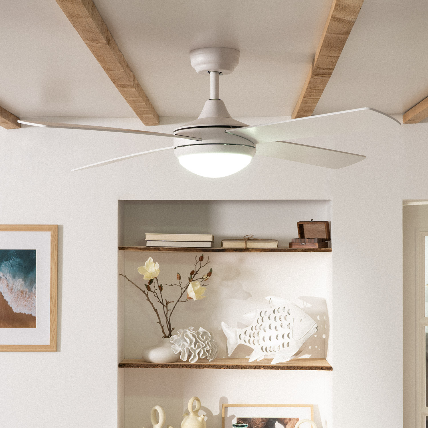 Un ventilatore a soffitto bianco con luce. È montato in un soffitto bianco con travi in legno.