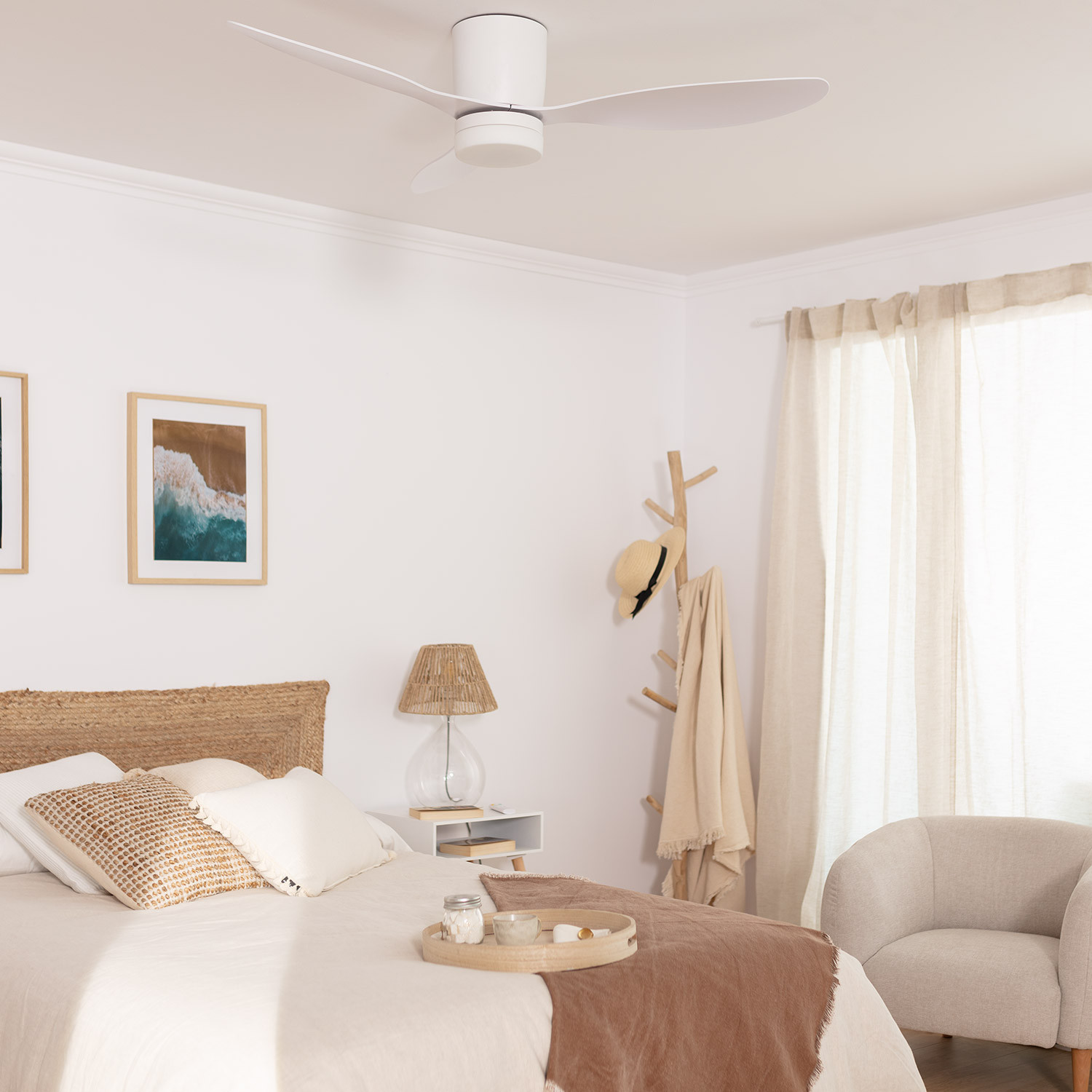 Camera da letto con ventilatore a soffitto, letto e decorazioni. Il ventilatore è bianco. La stanza è luminosa e ha colori neutri.
