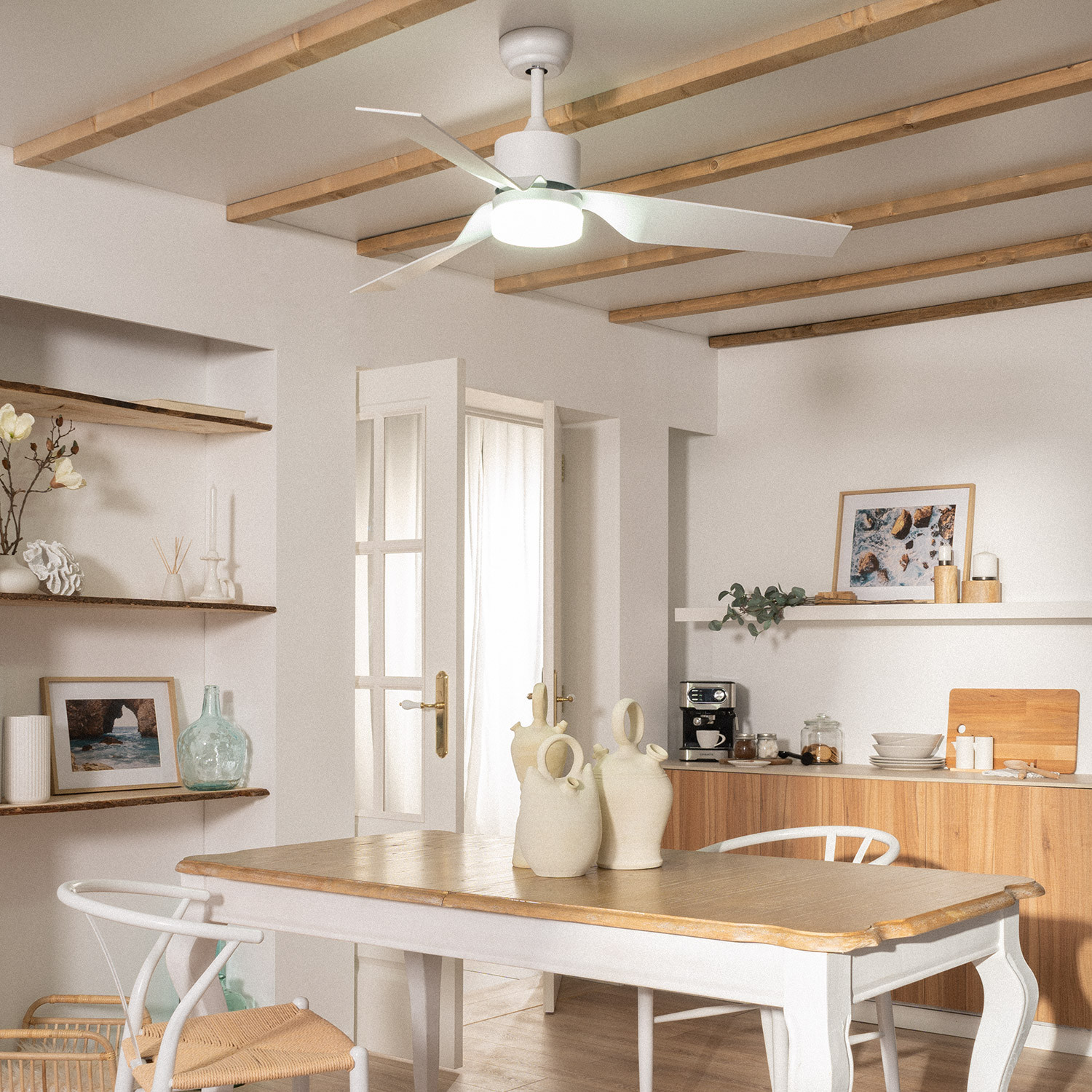 Una sala da pranzo con ventilatore a soffitto, tavolo con sedie e oggetti decorativi.