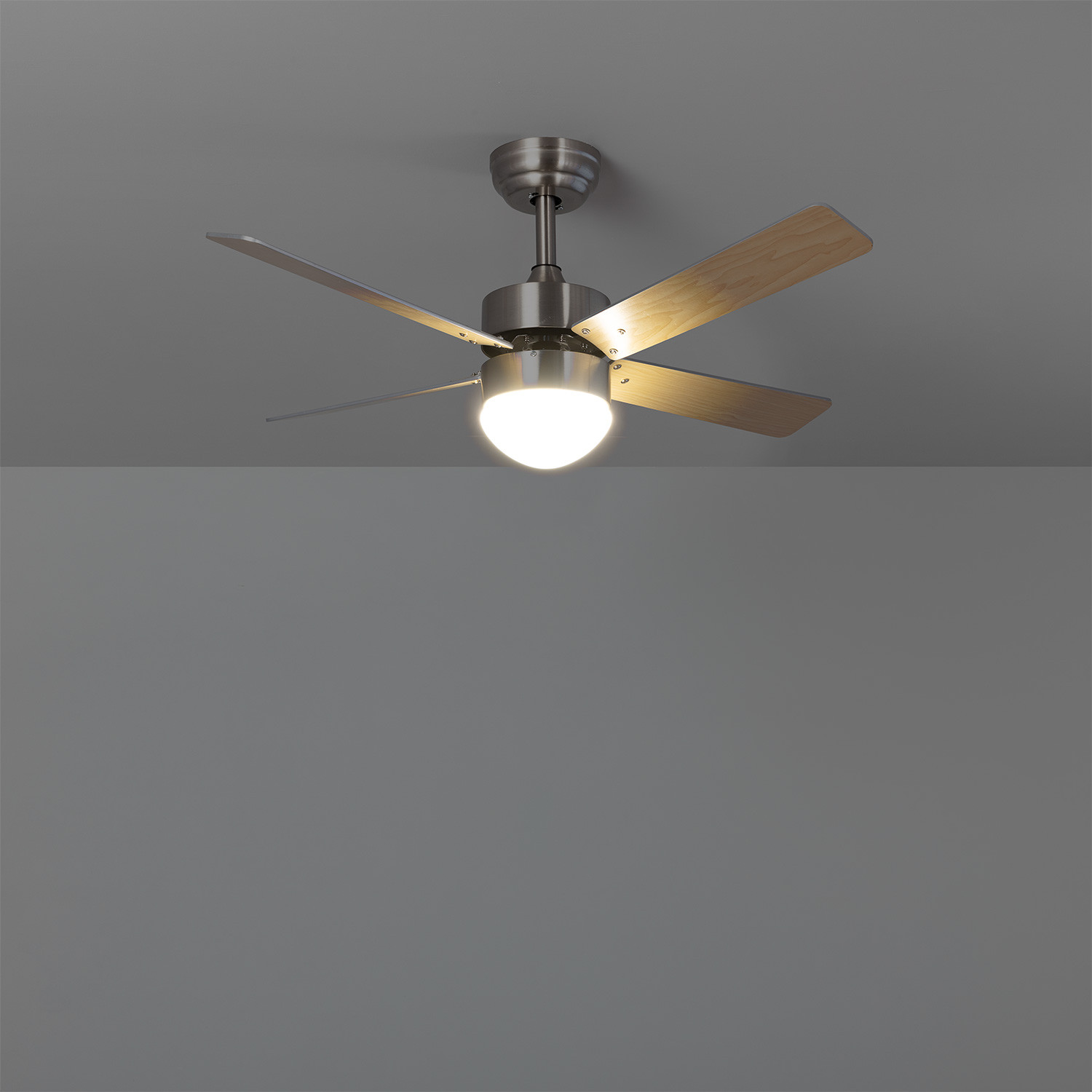 Ventilatore da soffitto con quattro pale in legno e una lampada. Sfondo: soffitto grigio.