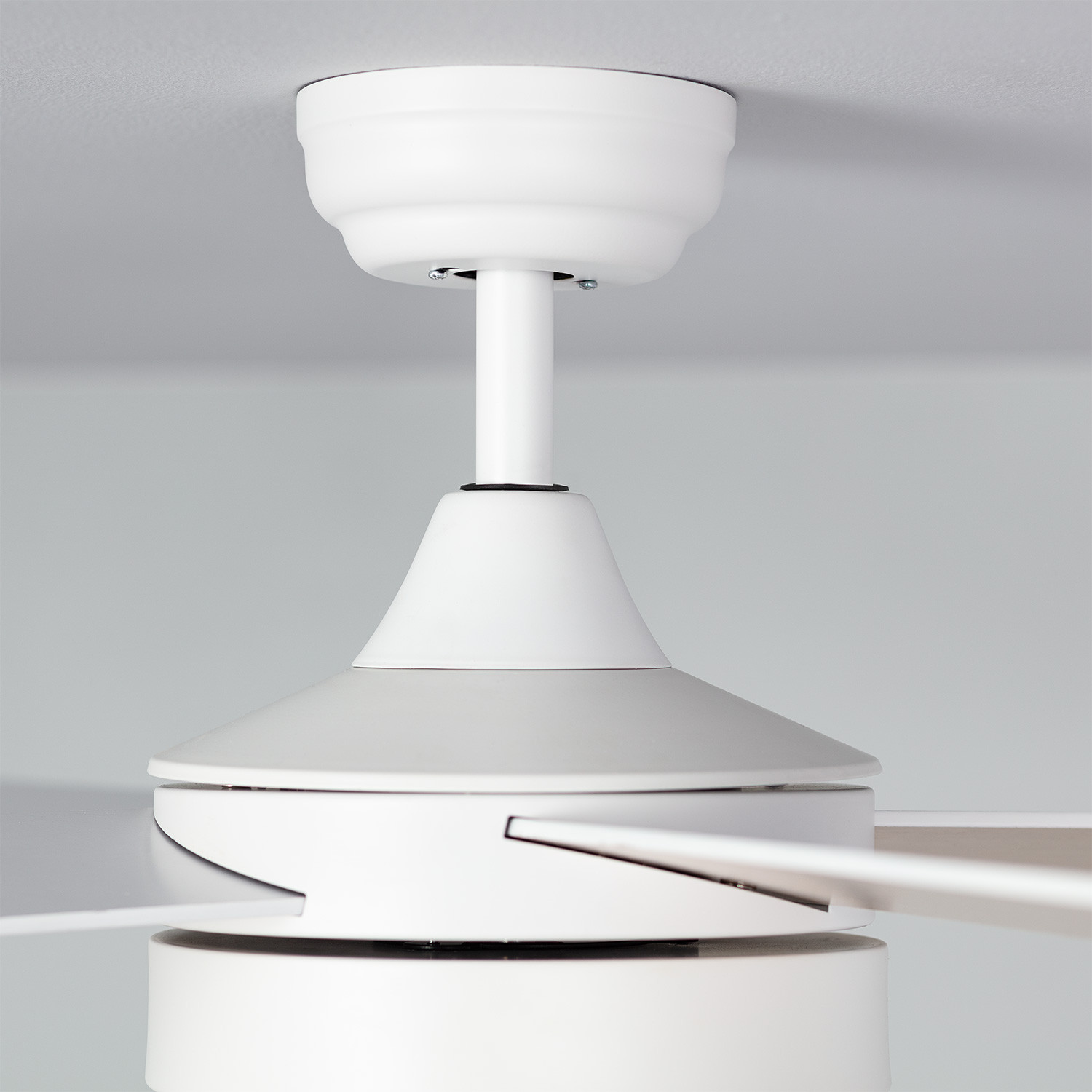 Ventilatore da soffitto bianco con pale bianche, montato su soffitto bianco. Lo sfondo è bianco.