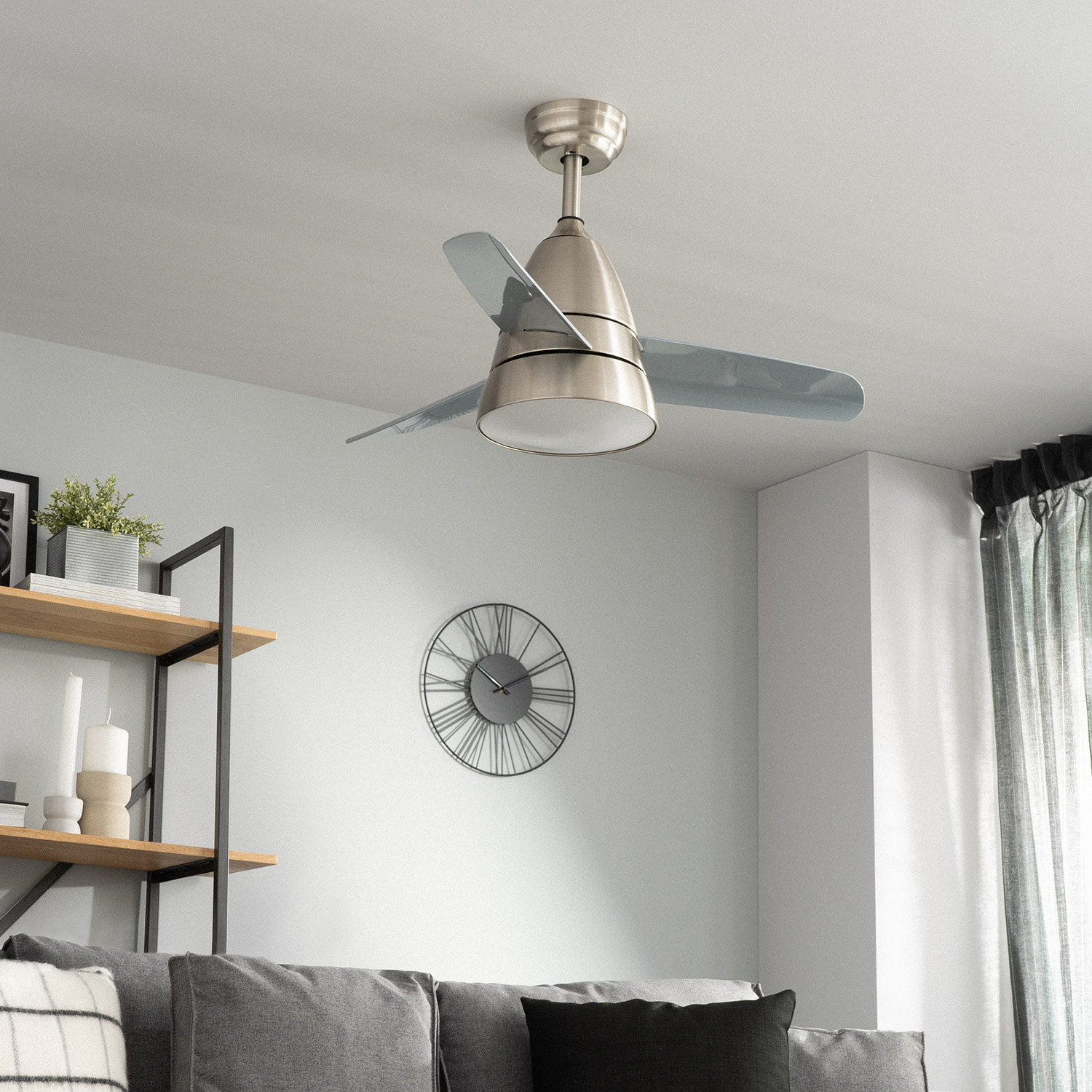 Ventilatore a soffitto con due pale. È argentato e lo sfondo è una stanza con un orologio e alcuni mobili.