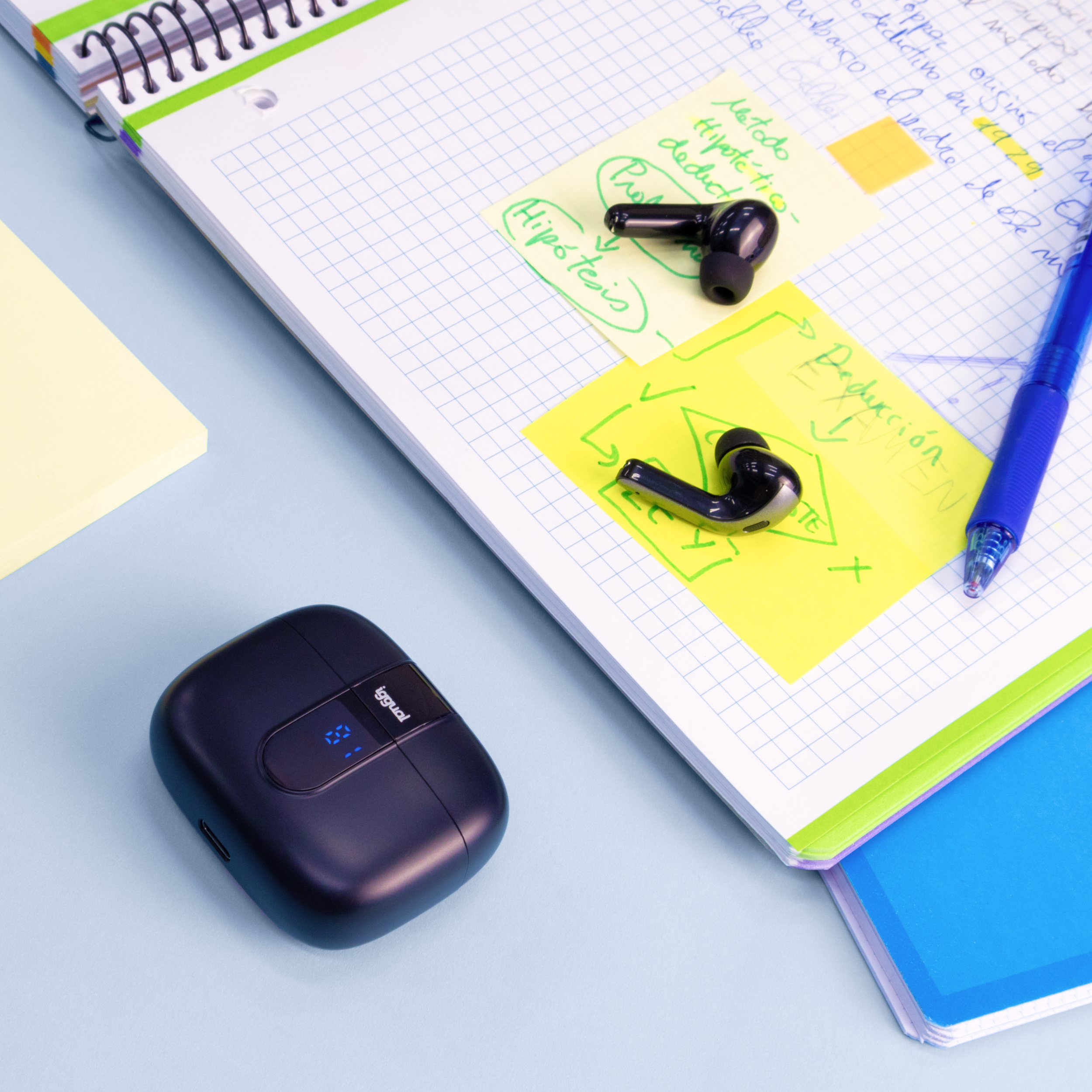Auricolari e custodia su una scrivania, con blocco note e penna, con post-it.