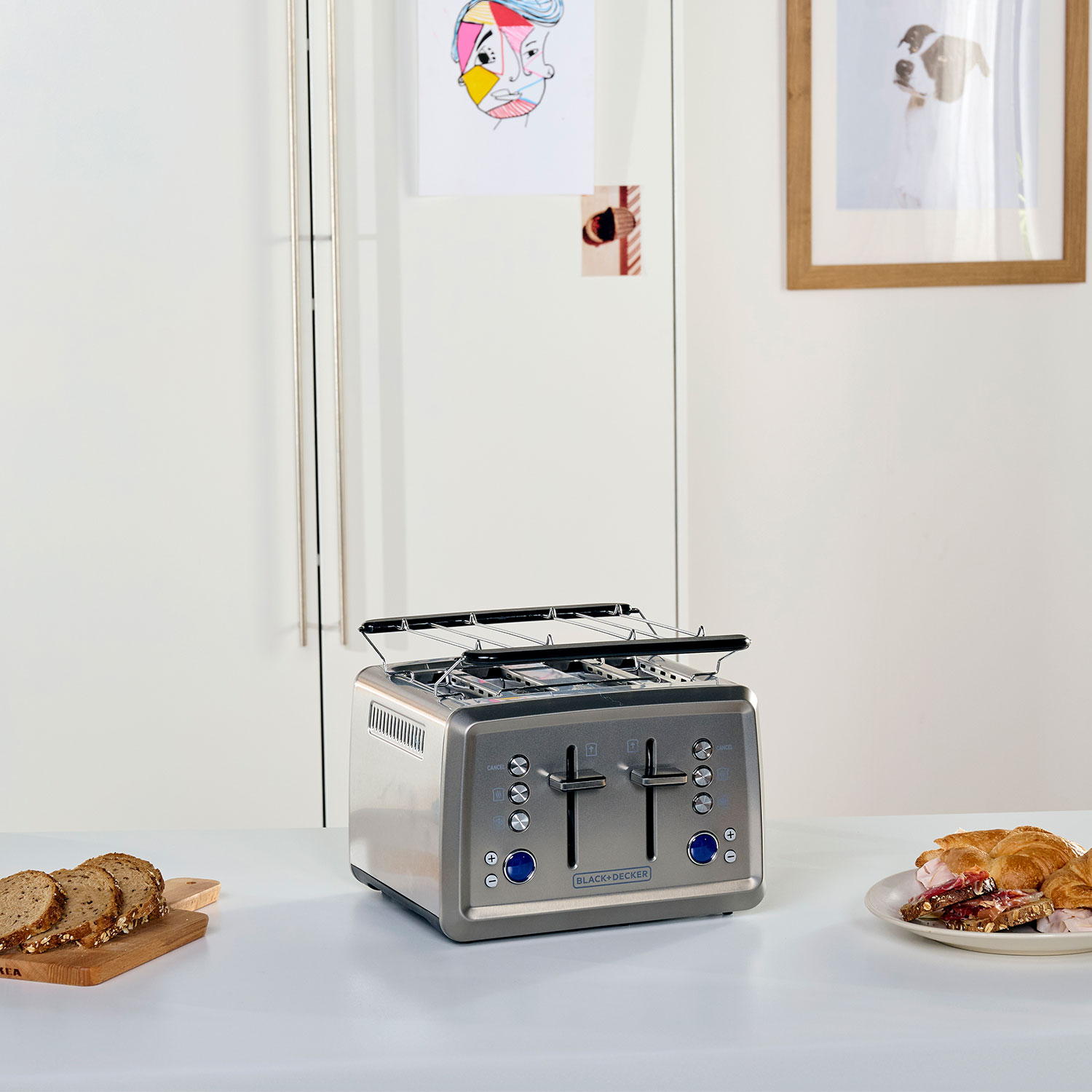 Ein Toaster auf einem Tisch mit Brot und Croissant.