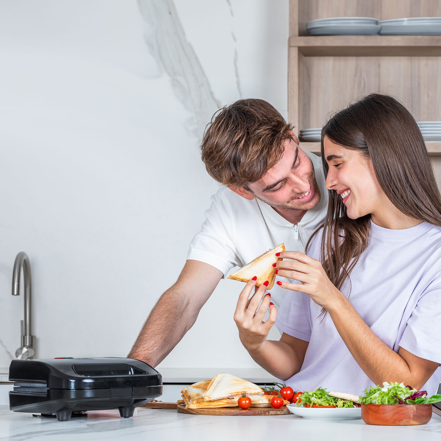 Para patrzy na kanapkę, z opiekaczem do kanapek.