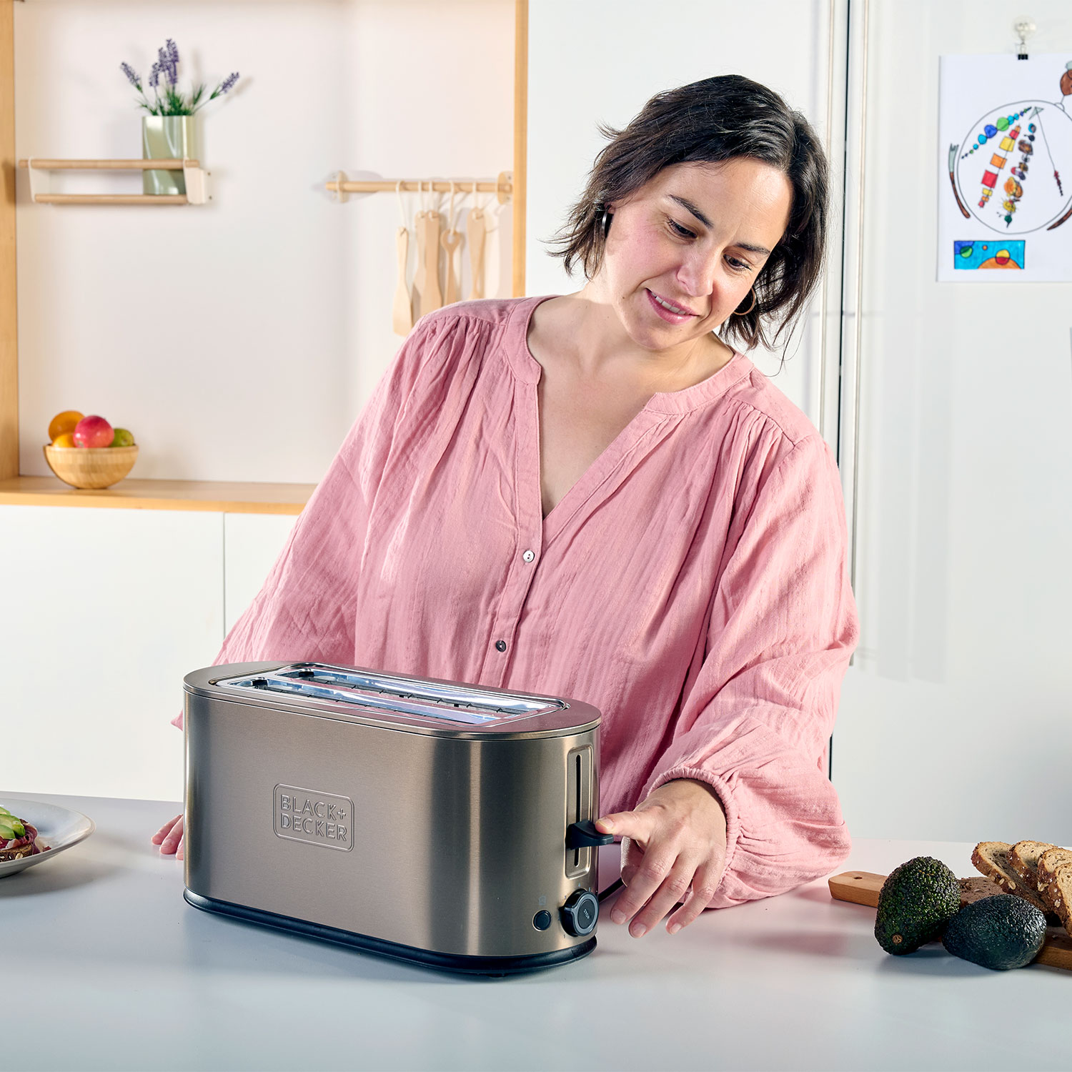 Frau bereitet Toast in einem silbernen Toaster zu, Küchenszene.