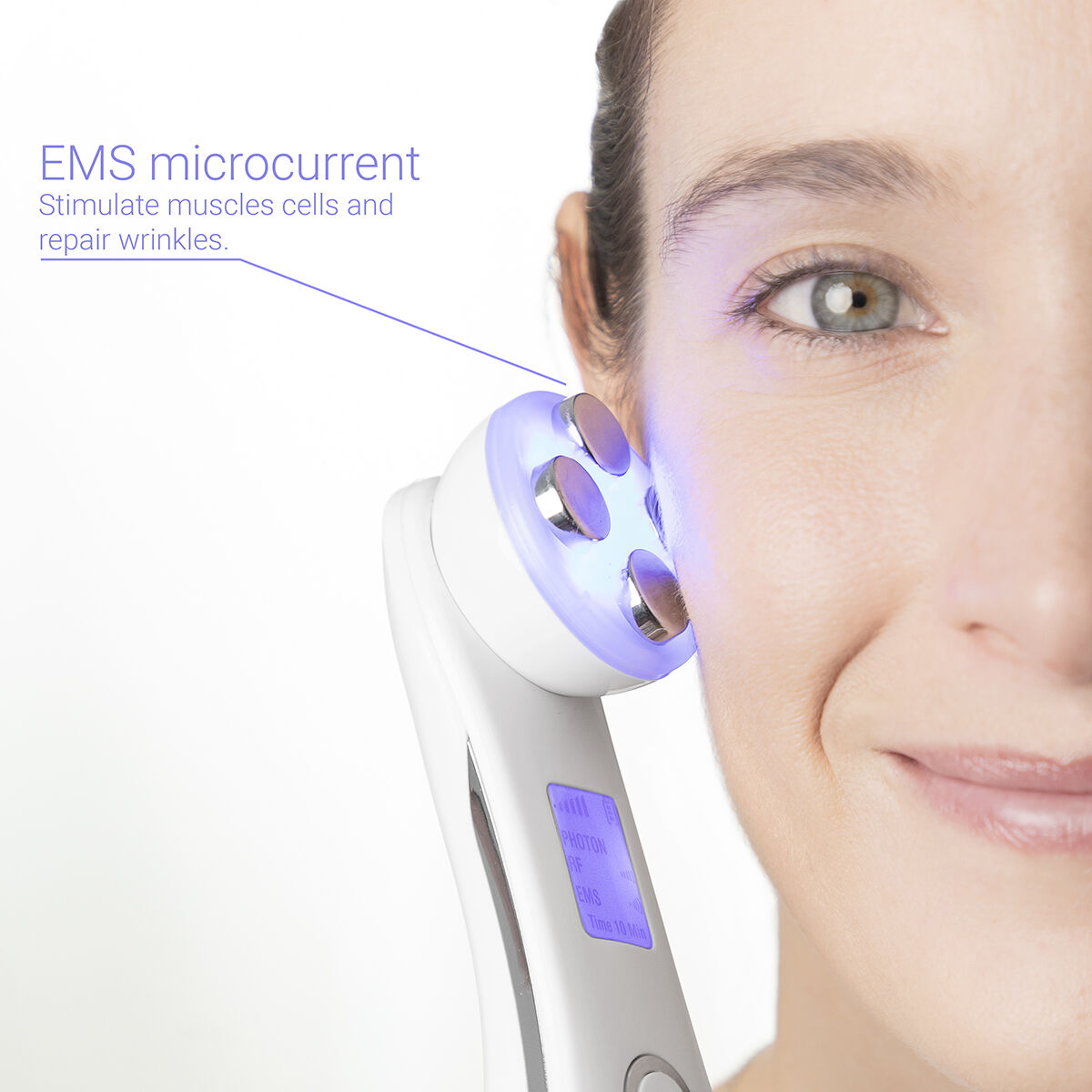 Mujer con un dispositivo de microcorriente en su rostro. Texto: microcorriente EMS. Luz azul.