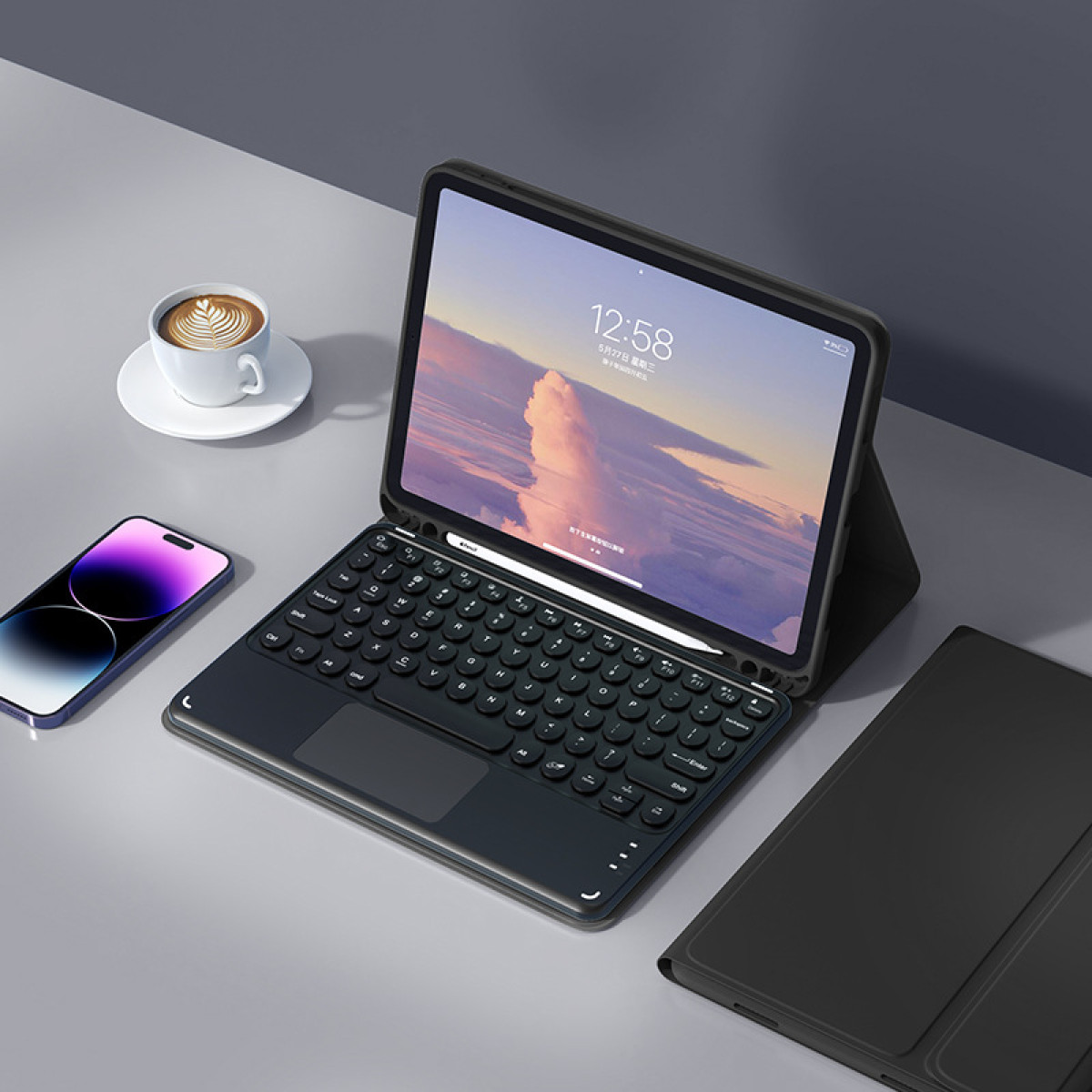 The image shows an iPad on a desk with a keyboard and a phone, a coffee cup is also visible.