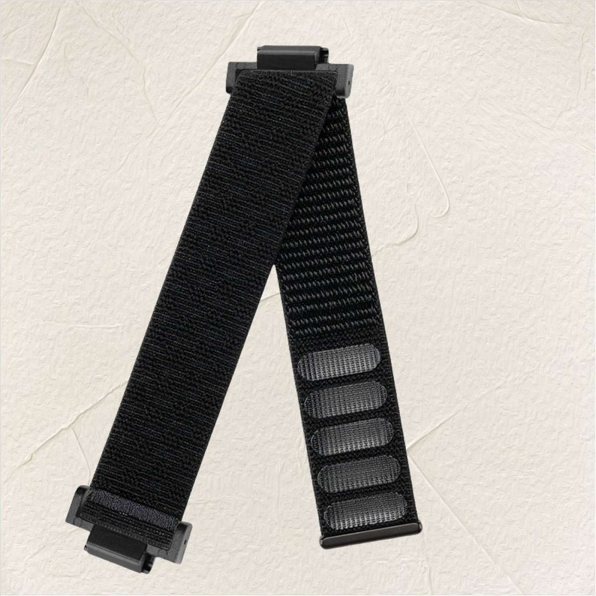 Schwarzes Uhrenarmband mit schwarzen Anschlüssen vor strukturiertem weißem Hintergrund.