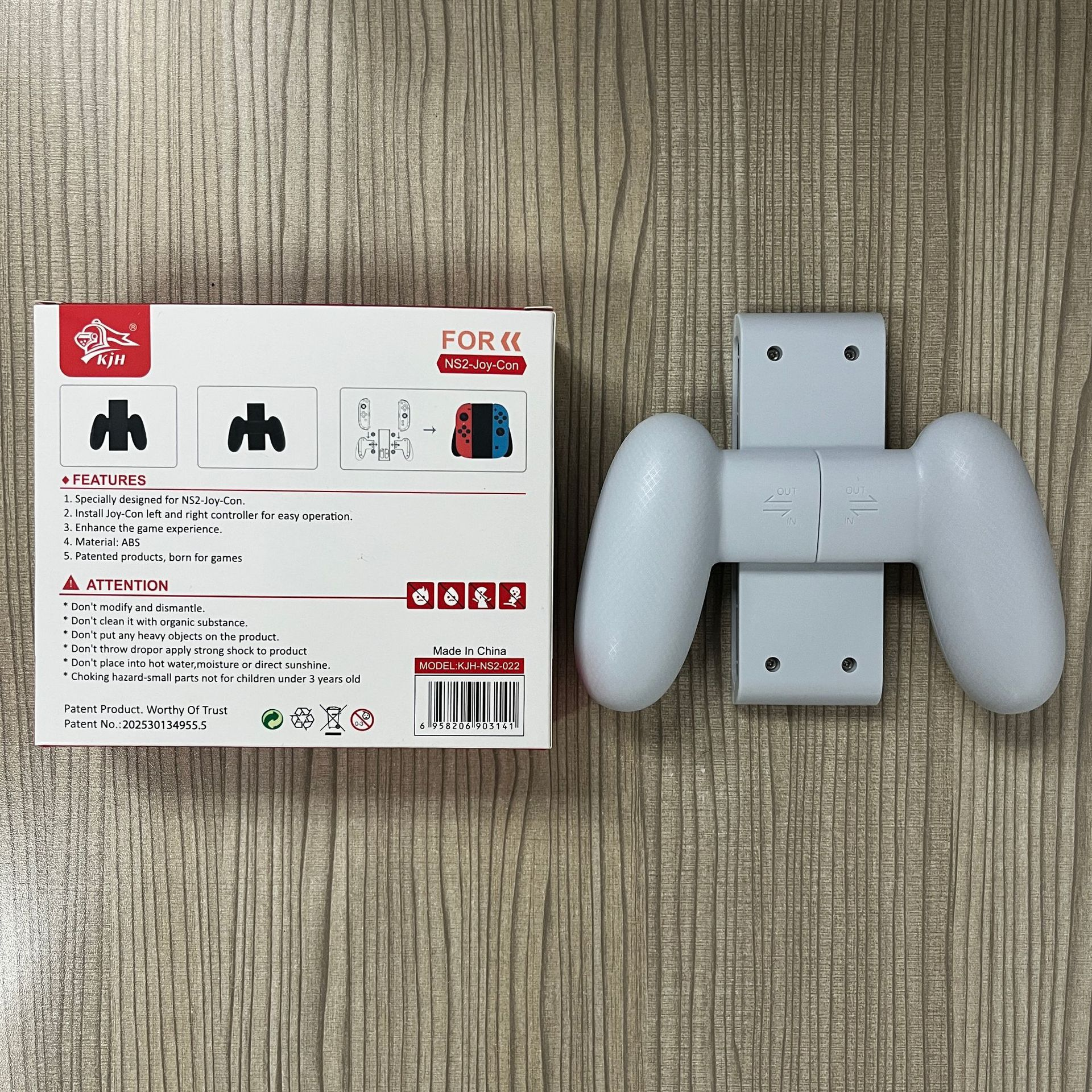 Box with controller holder and controller. White holder with grips and a white controller is next to it.
