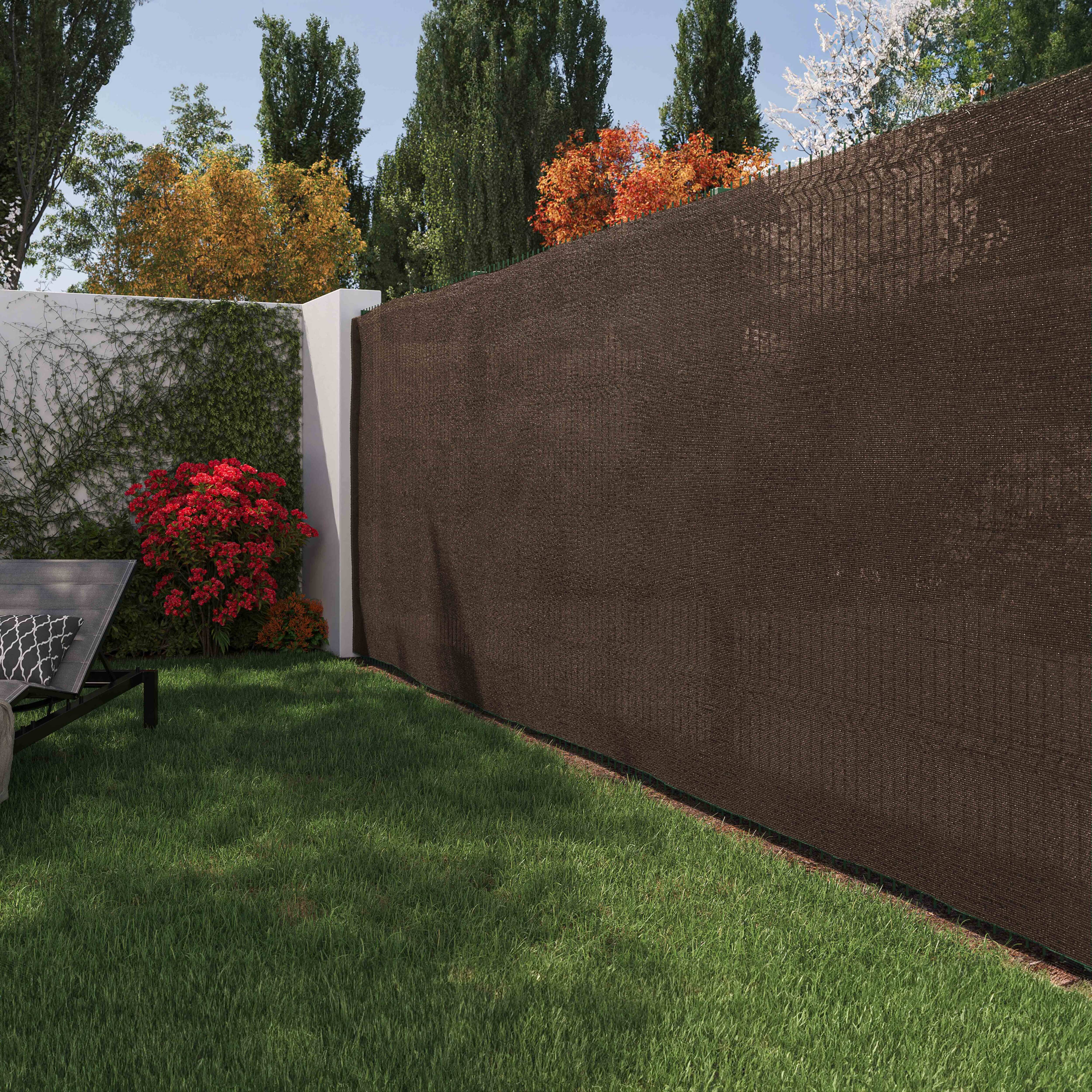 Brauner Maschendrahtzaun, Gartenansicht, weiße Wand.
