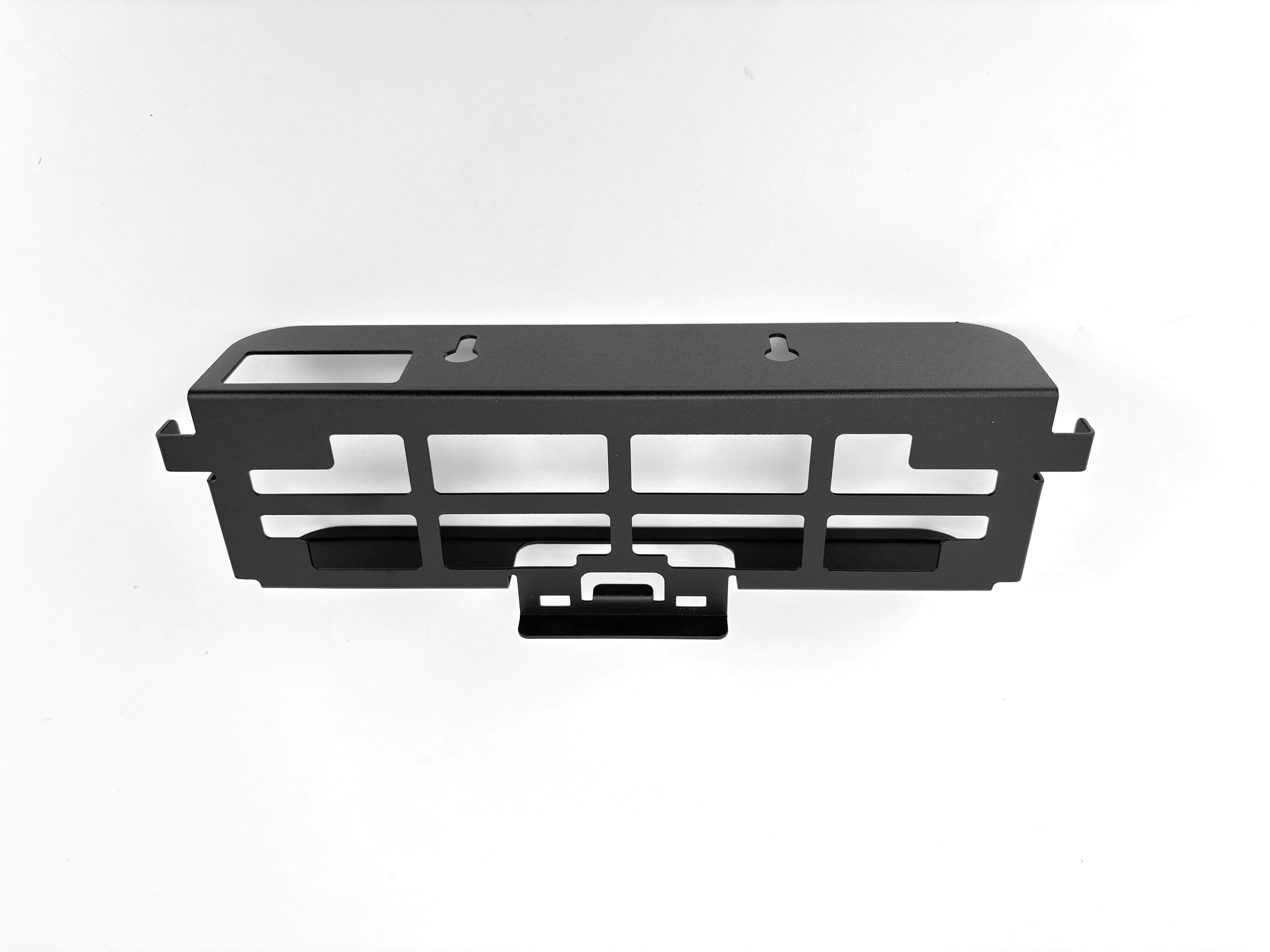 Czarny metalowy uchwyt do konsoli z wycięciami na kontrolery na białej powierzchni.