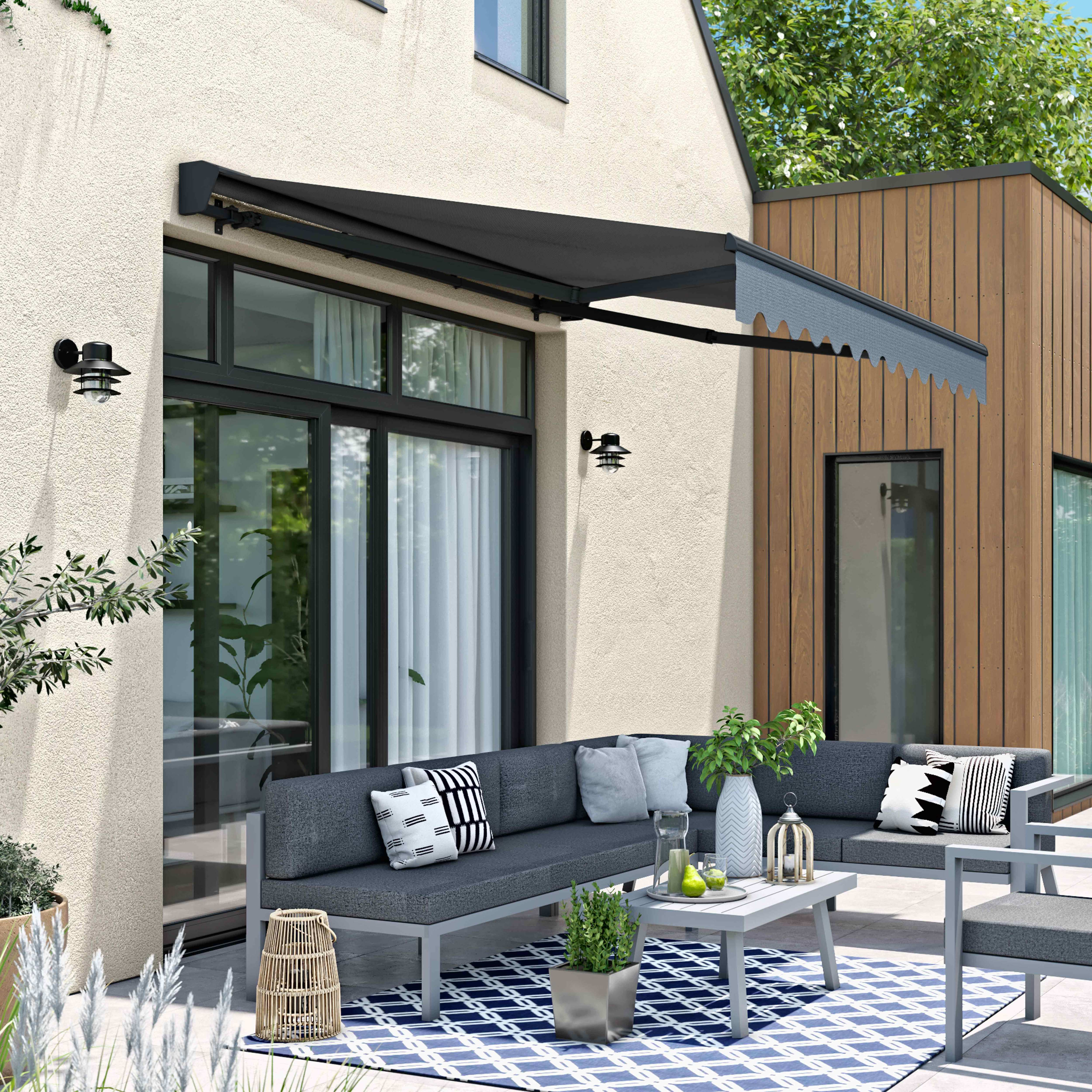 Markise über Terrasse mit Möbeln, blauer Himmel.