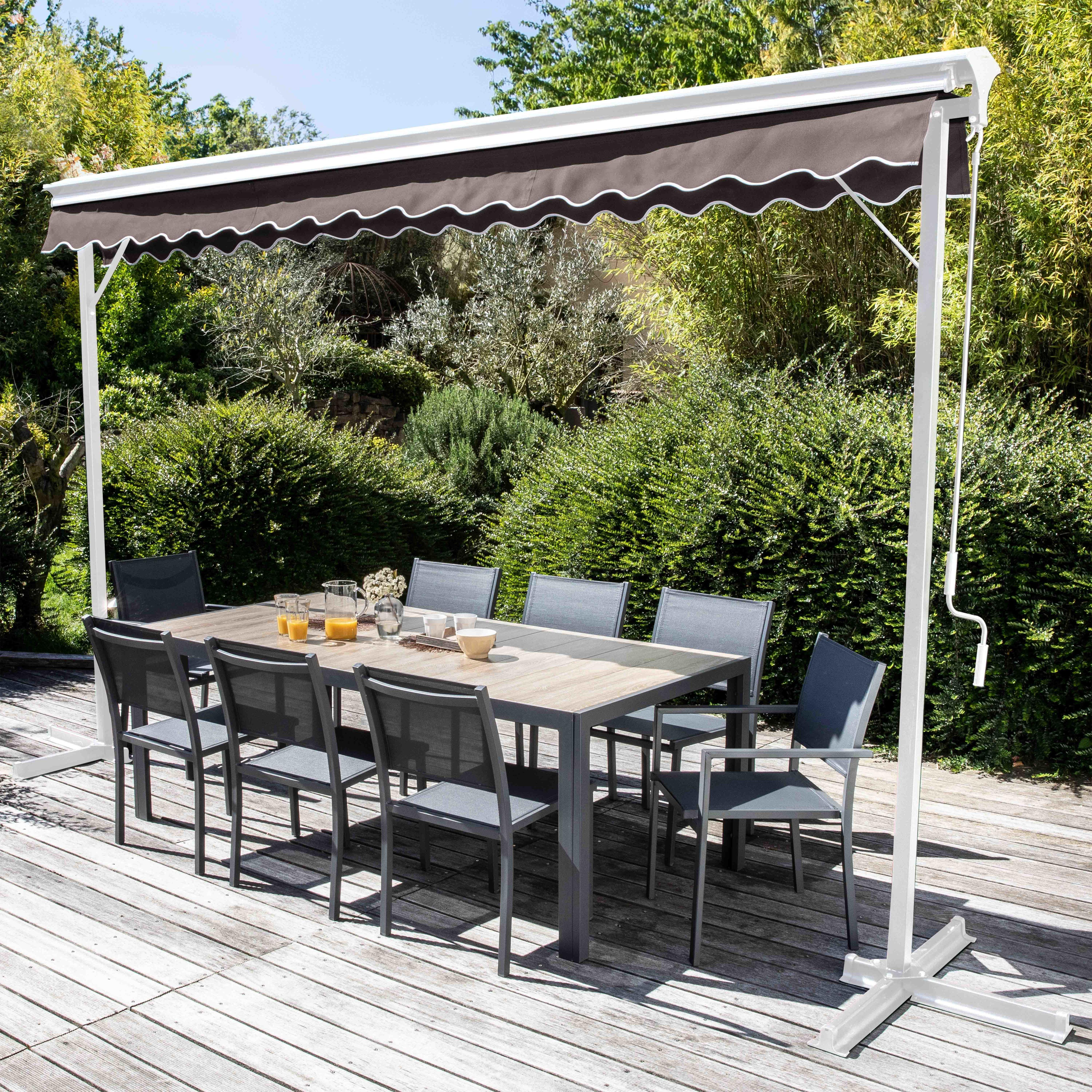 Patio-Szene: Tisch, Stühle unter Markise. Getränke auf dem Tisch. Grüner Hintergrund.