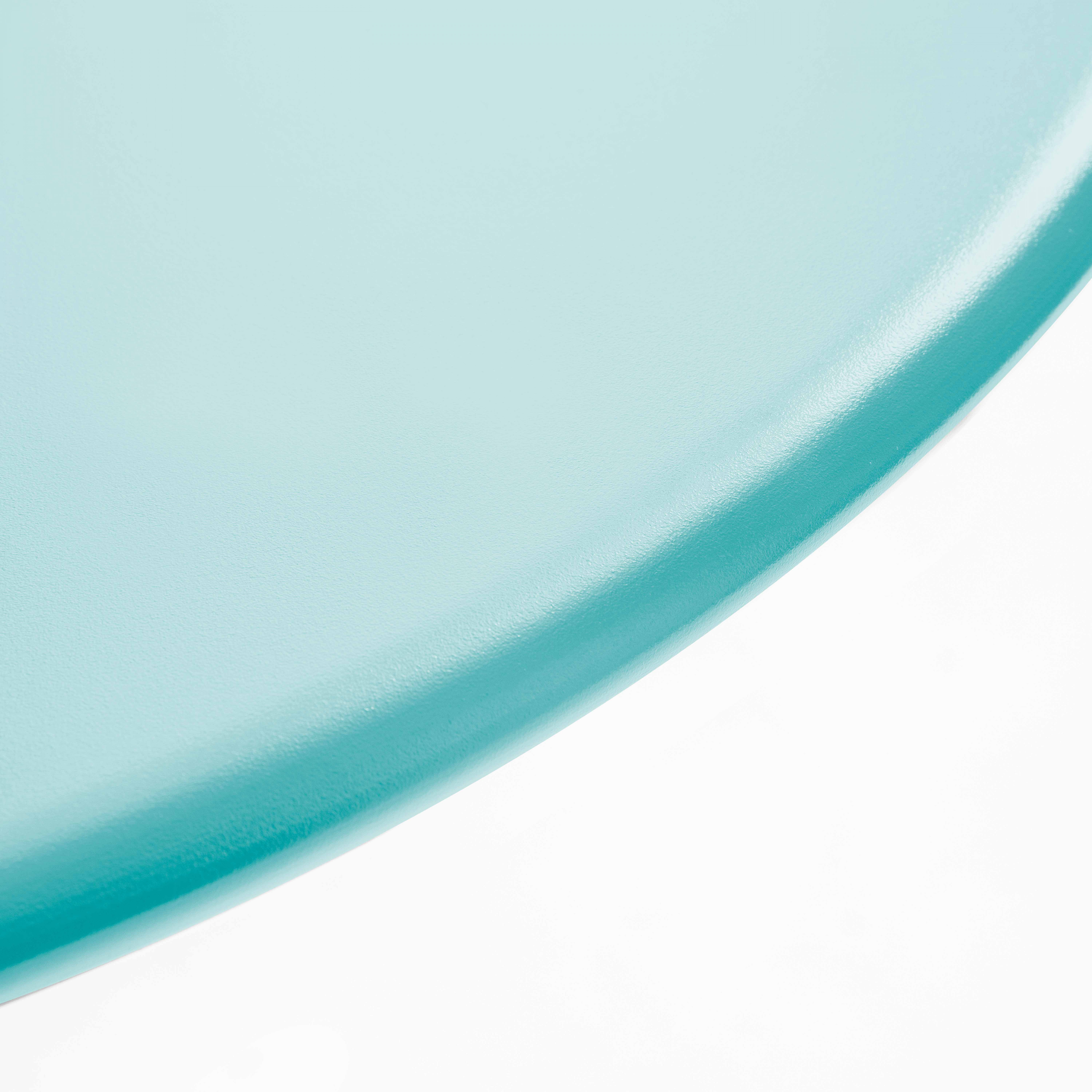 Nahaufnahme einer blauen Tischkante. Abgerundete Kante und weißer Hintergrund.