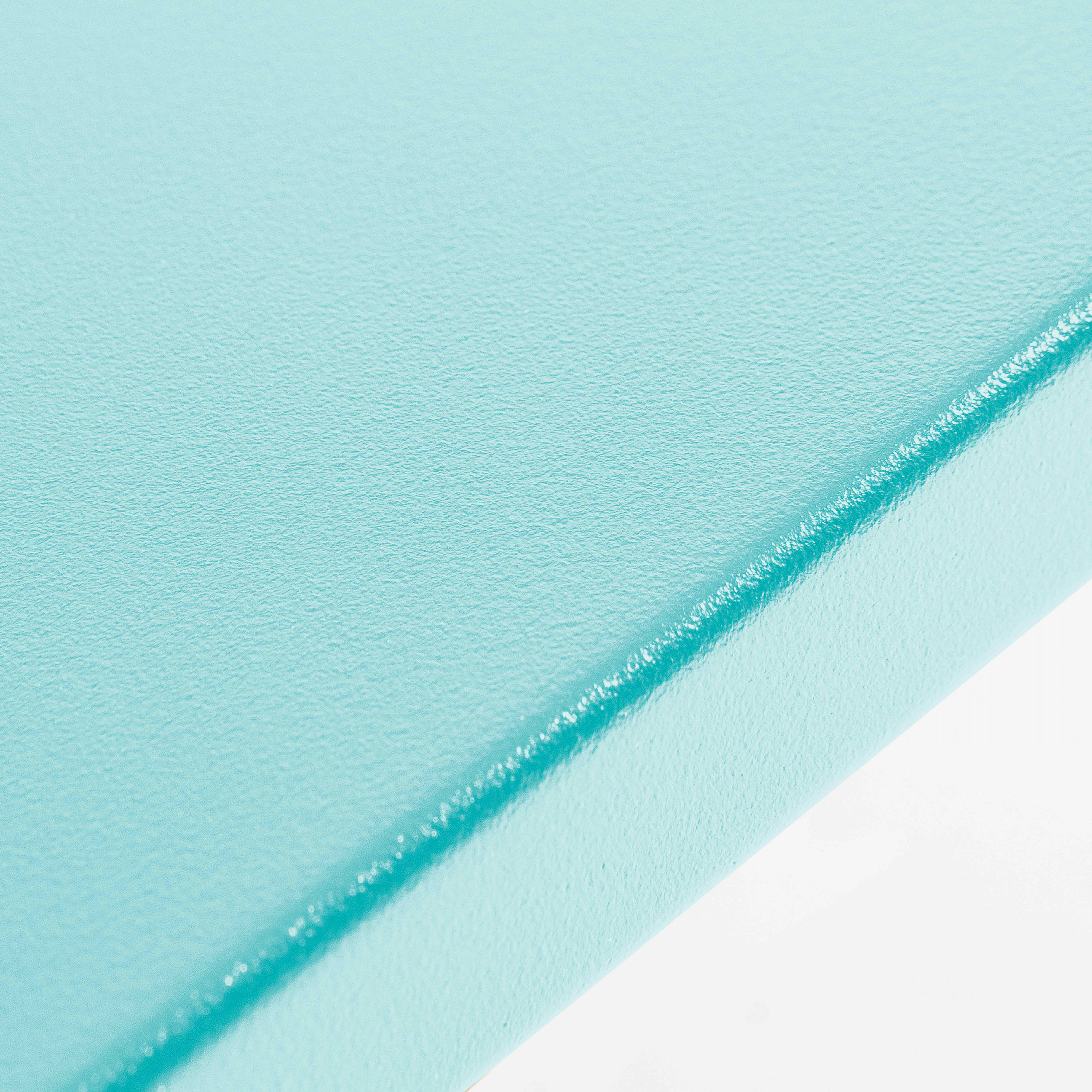 Eine Nahaufnahme einer glatten, hellblauen Oberfläche mit einer subtilen Textur, möglicherweise Metall oder lackiertes Material.