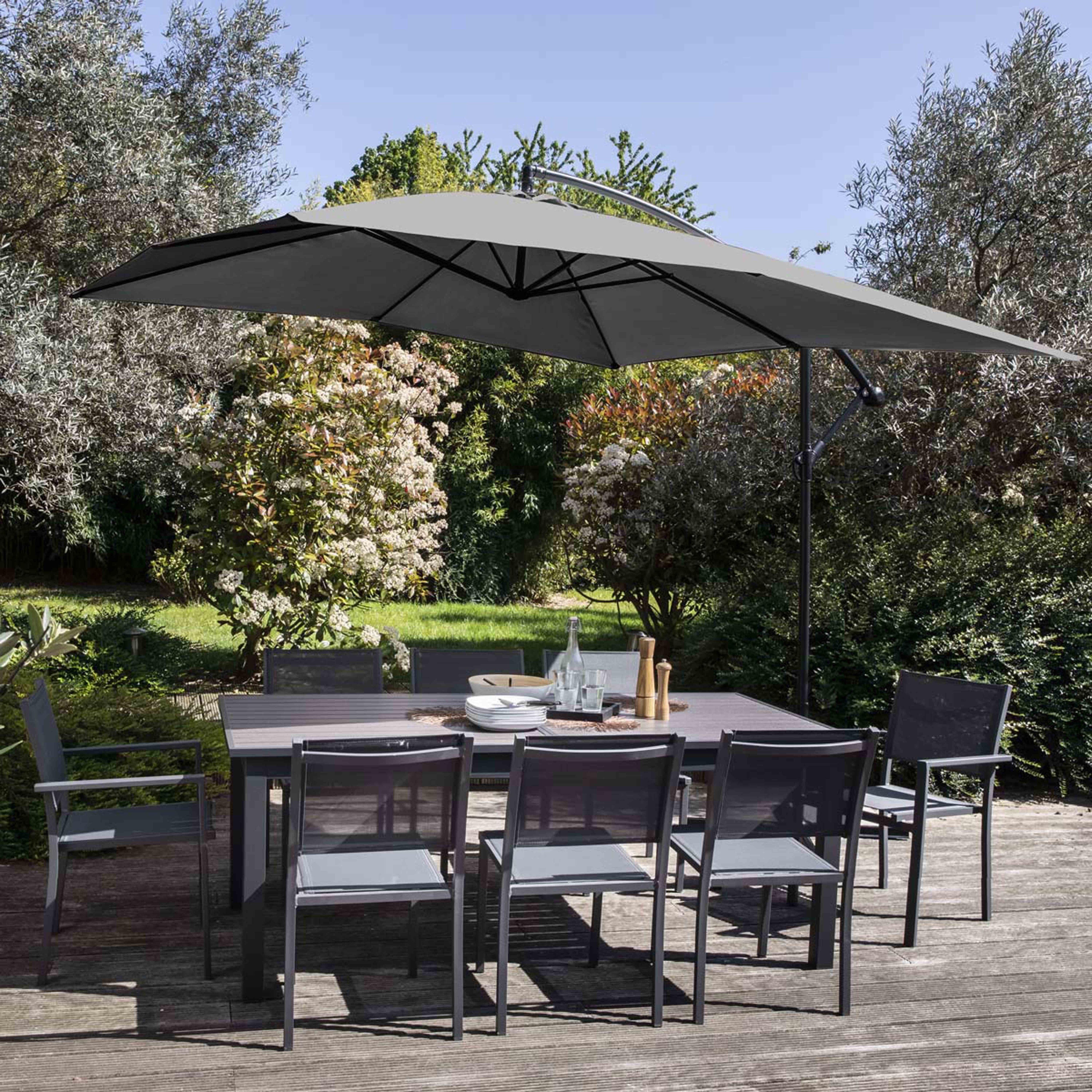 Essgruppe im Freien mit Tisch, Stühlen und großem grauem Sonnenschirm.
