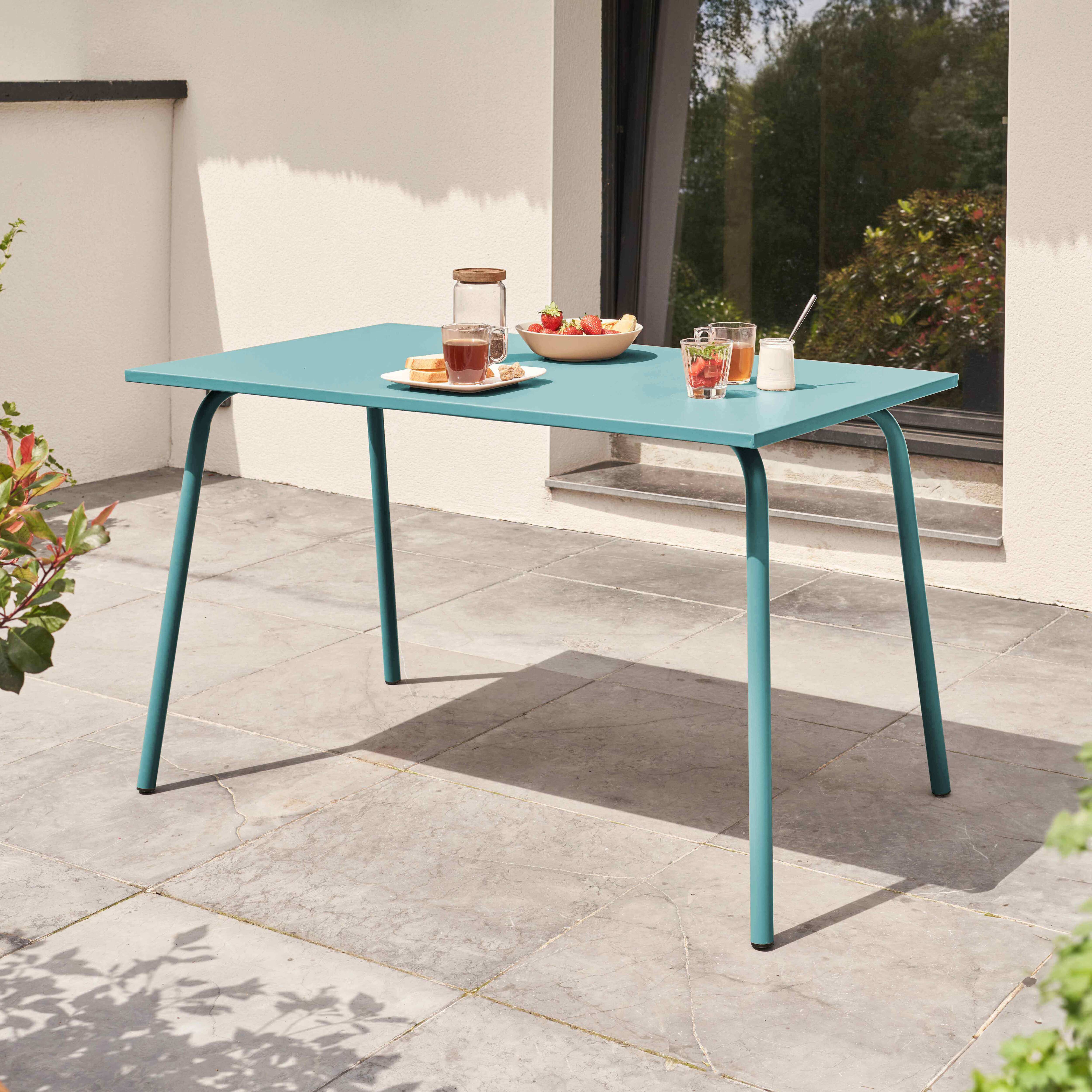 Türkisblauer Gartentisch mit Essen und Getränken auf der Terrasse.
