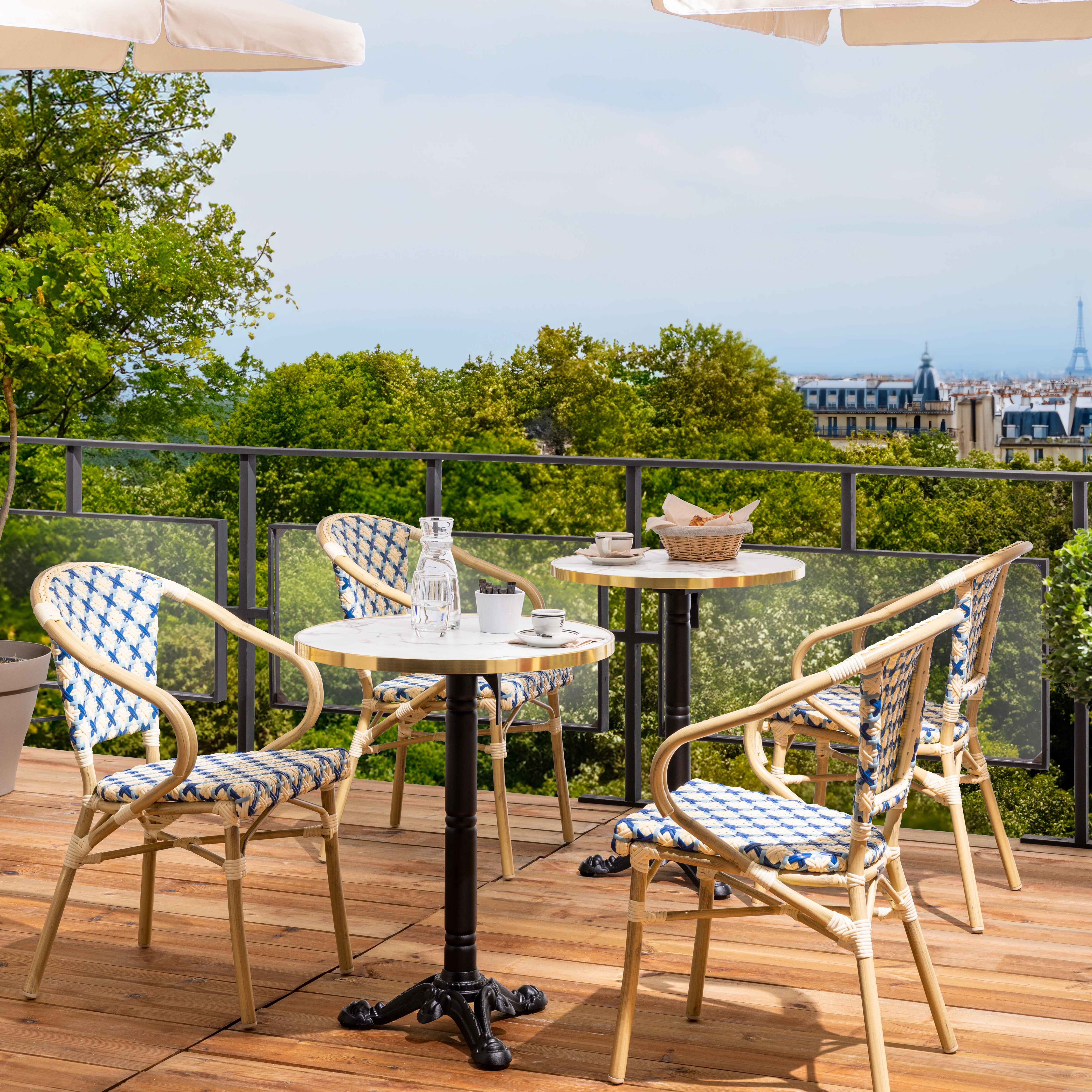 Café-Szene im Freien mit Tischen, Stühlen und dem Eiffelturm.