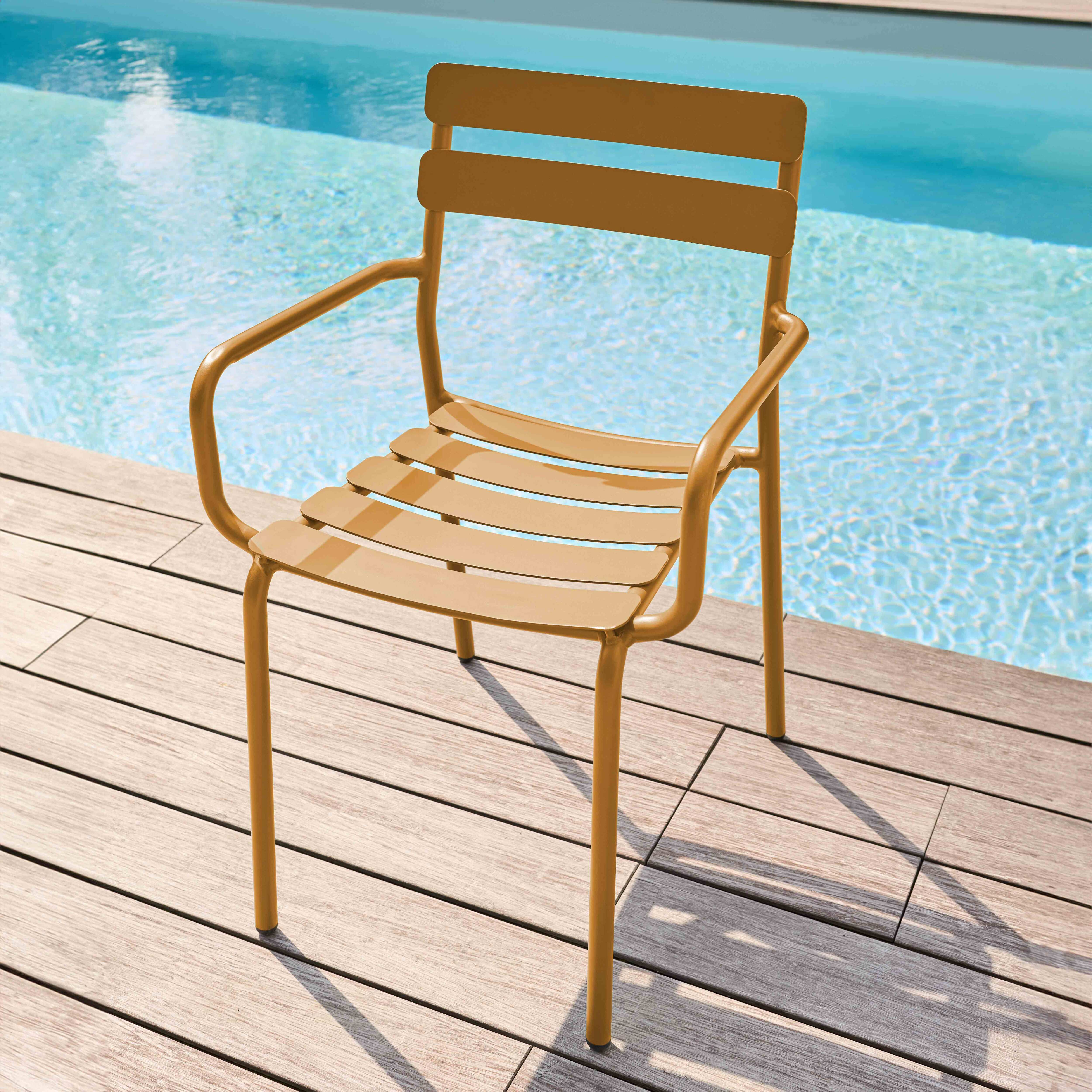 Ein Senfstuhl am Pool, mit Lattenrücken und Armlehnen auf Holzterrasse.