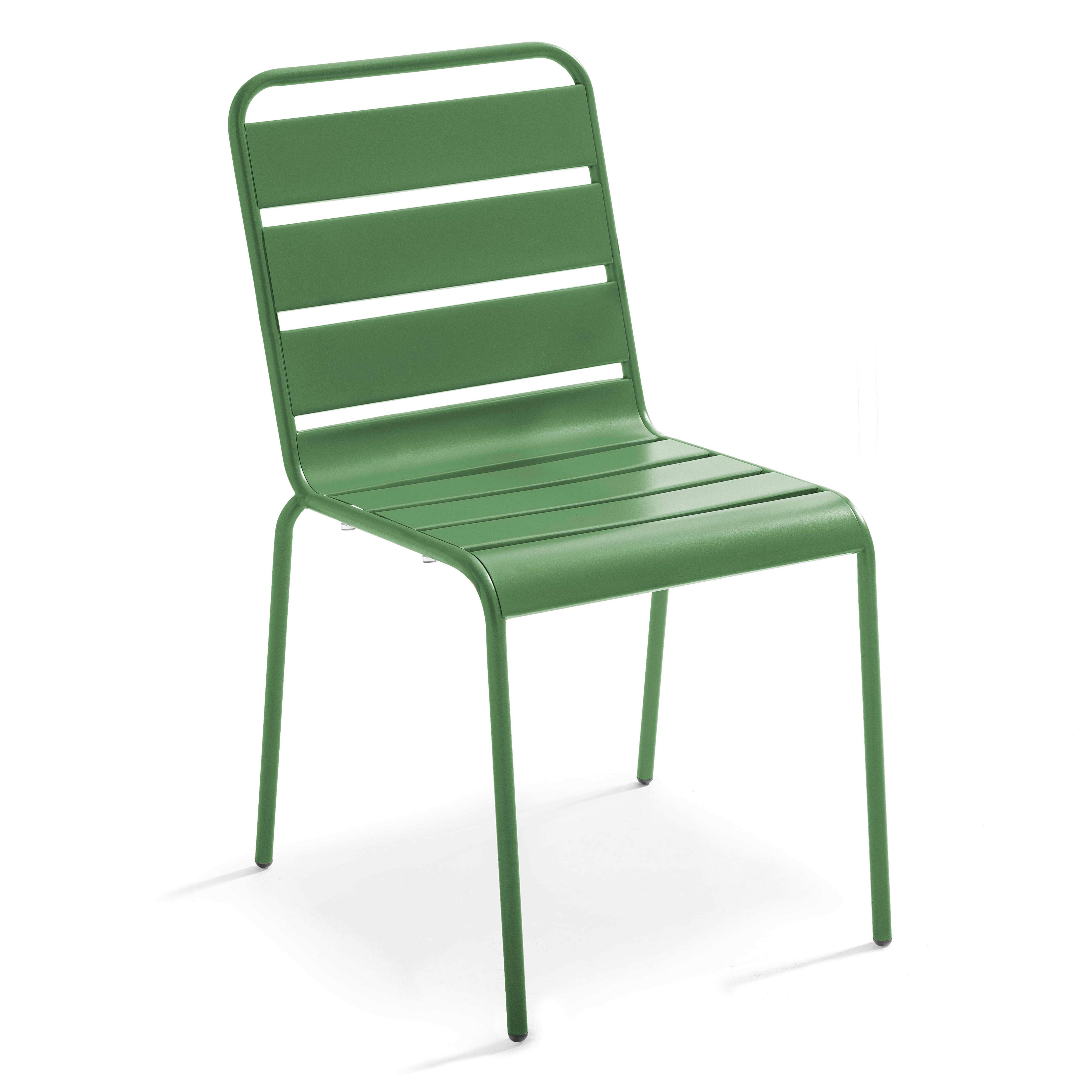 Grüner Metallstuhl mit horizontalen Latten an Rückenlehne und Sitzfläche, stehend auf einer weißen Oberfläche.