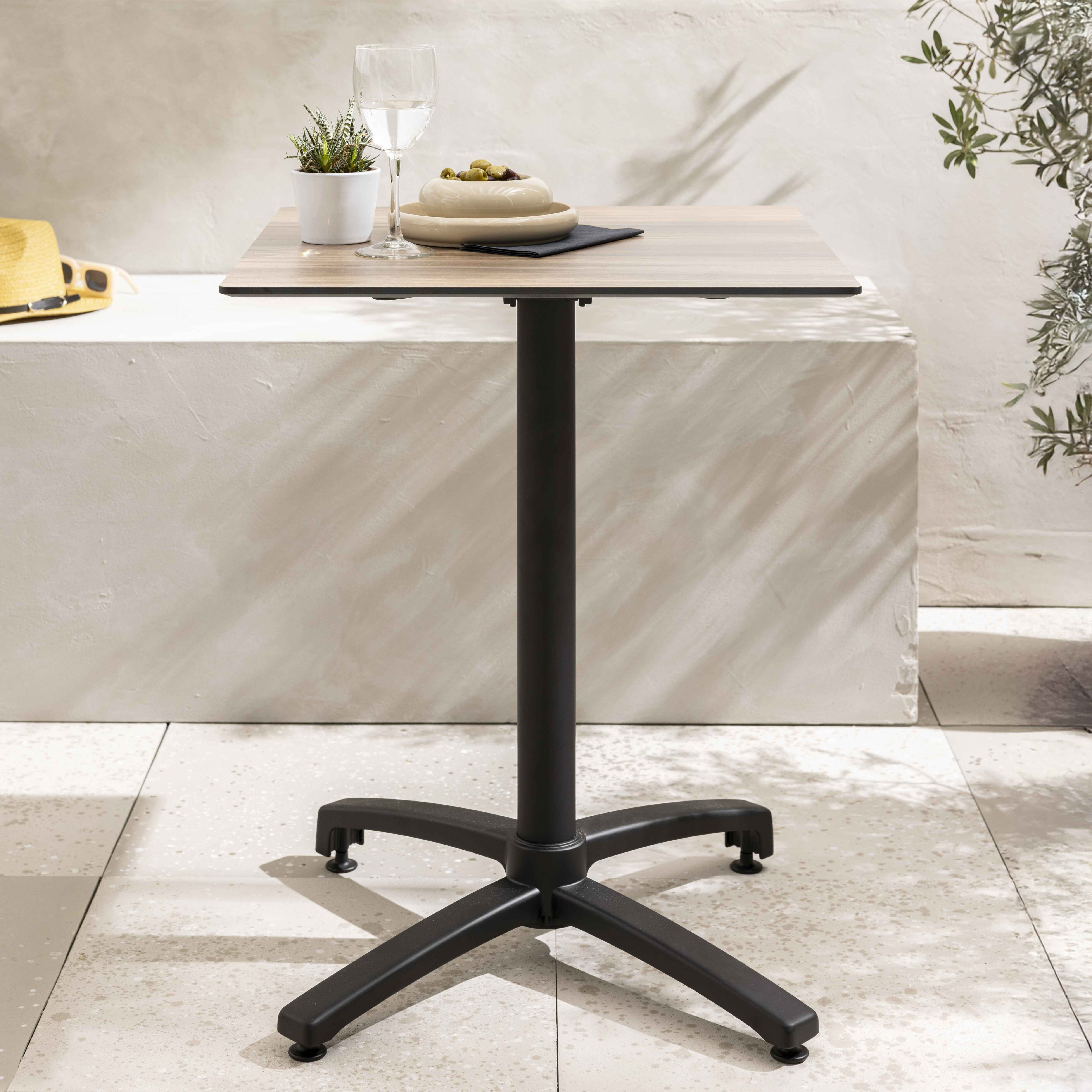 Quadratischer Outdoor-Tisch mit schwarzem Fuß und hellbrauner Platte.