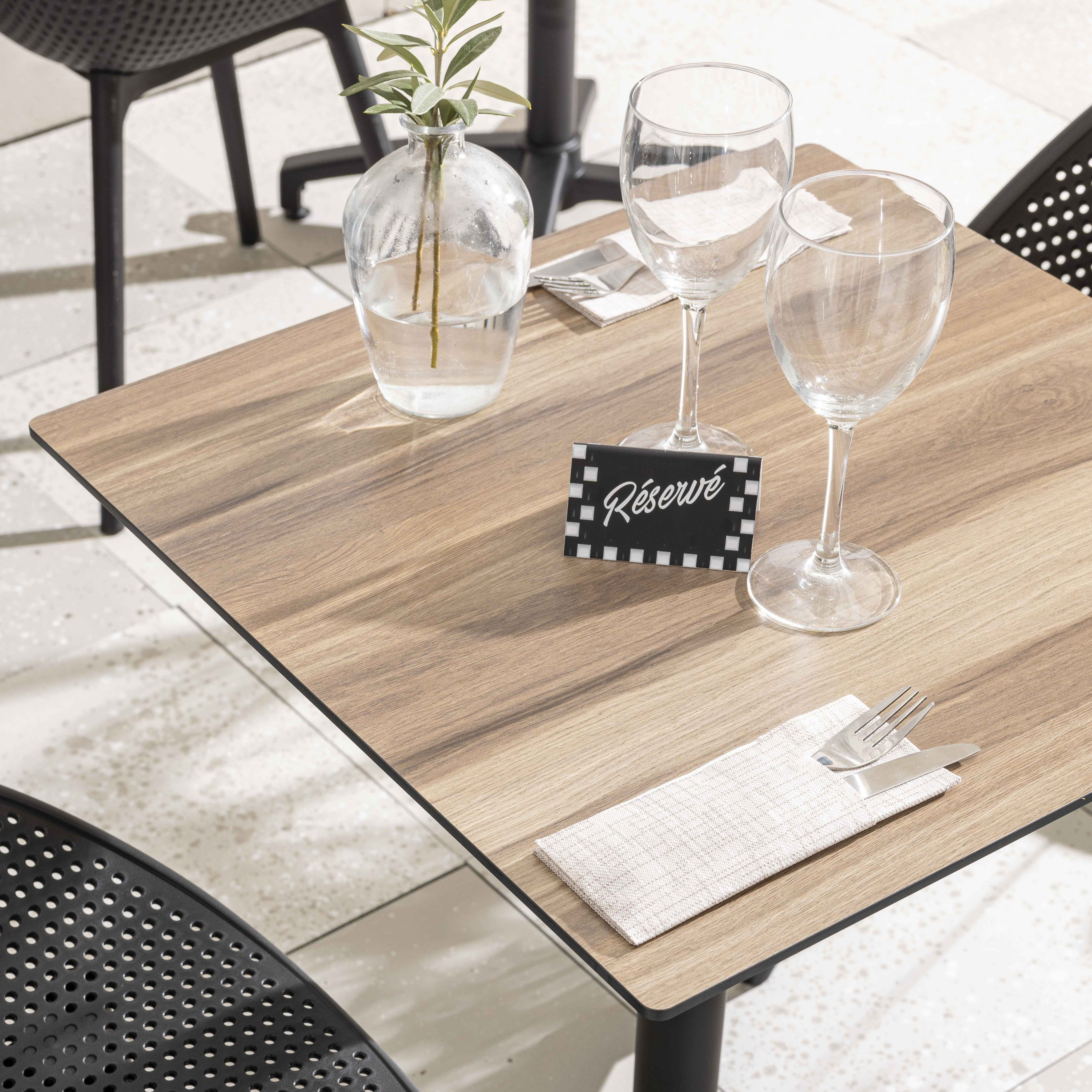 Tisch mit Reserviert-Schild, Gläsern und Vase mit Pflanze. Restaurant-Szene.
