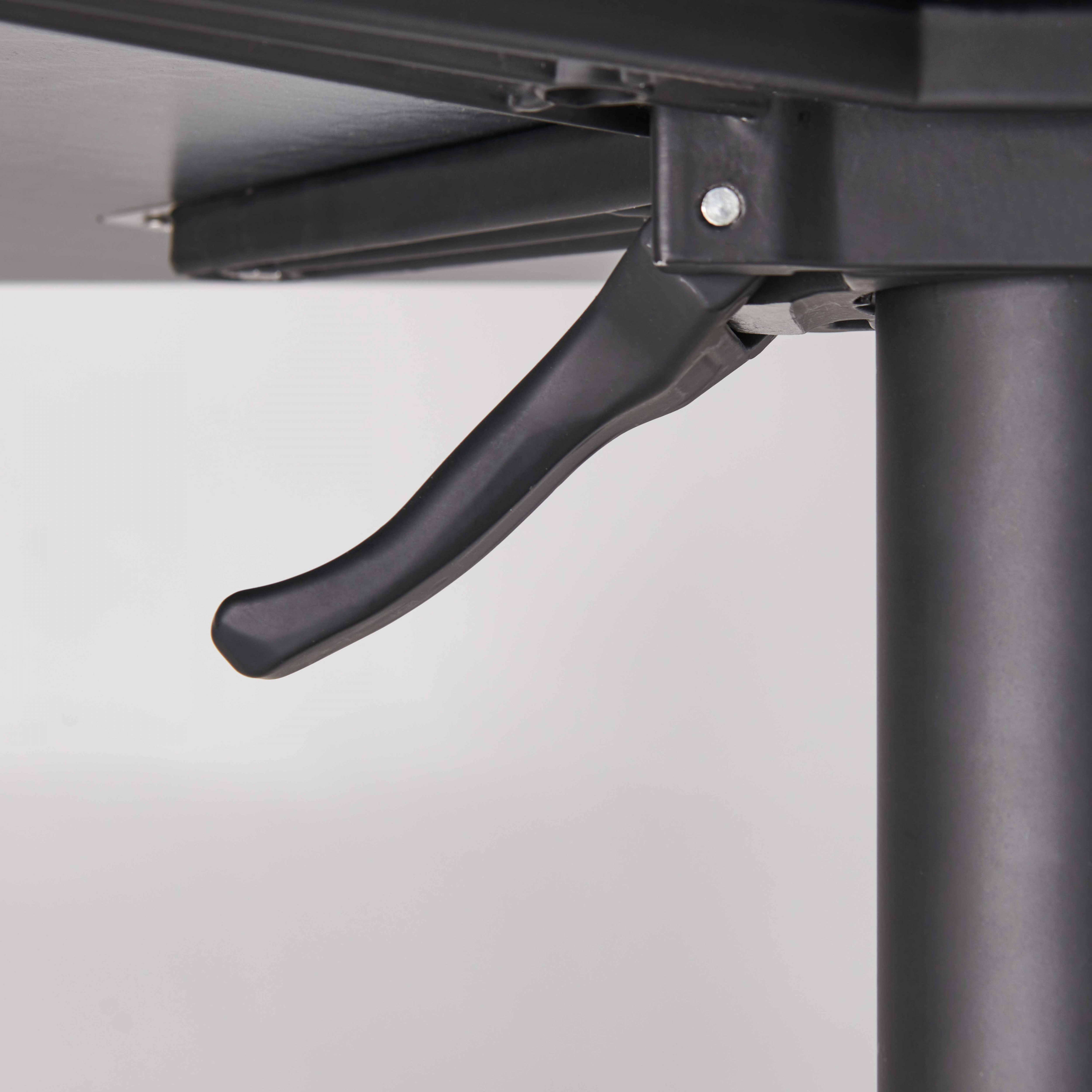 Nahaufnahme des Kippmechanismus eines schwarzen Tisches, mit Hebel und dunkler Oberfläche.