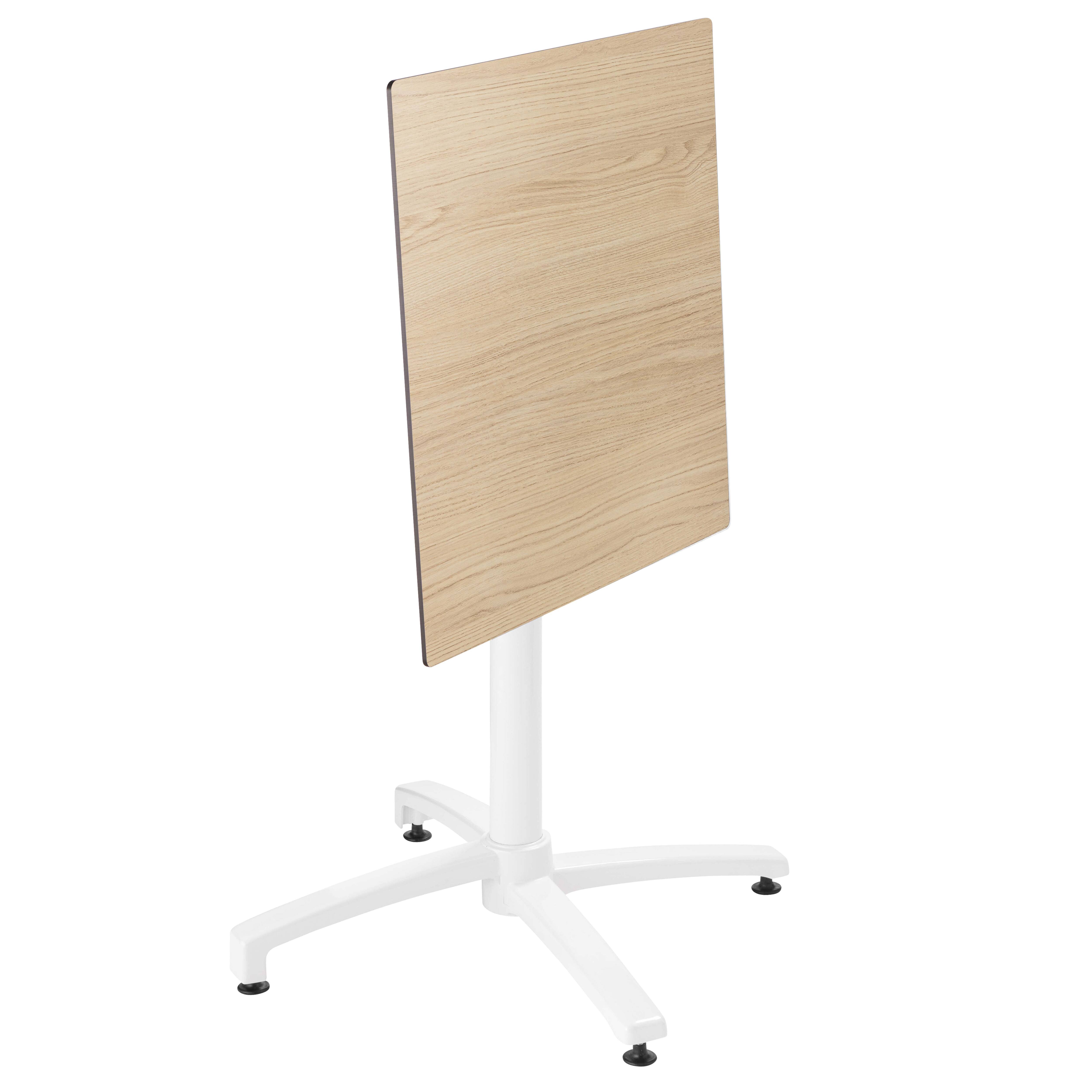 Ein Tisch aus hellem Holz mit weißem, vierbeinigen Gestell, isoliert auf Weiß.