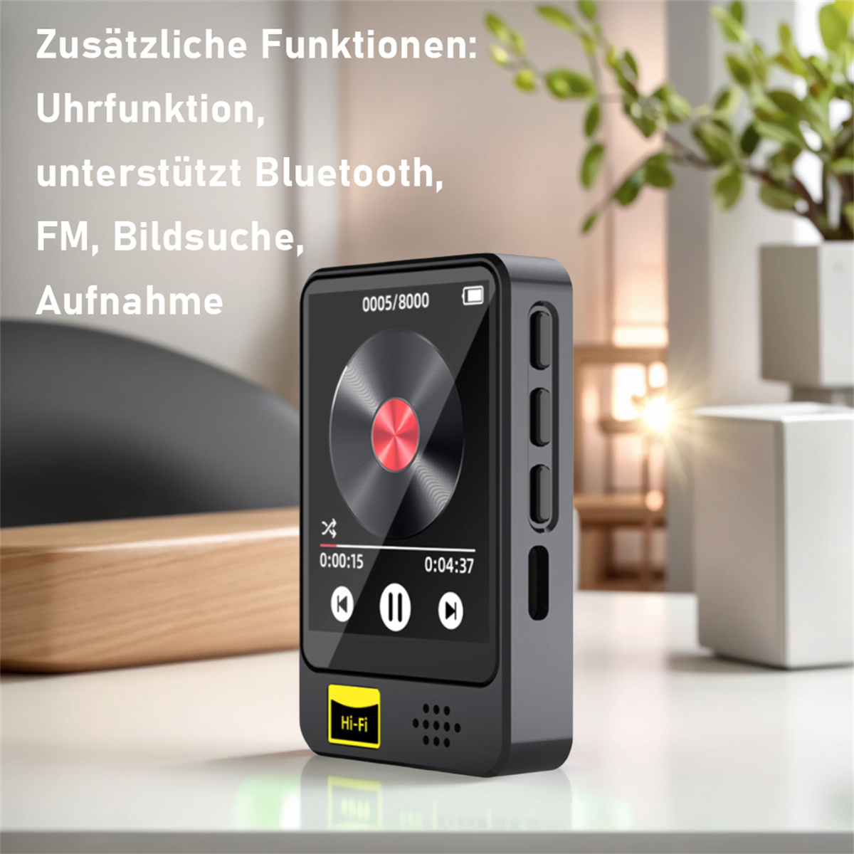 Schwarzer Musikplayer mit Bildschirm und Text auf einem Tisch. Weißer Hintergrund mit unscharfen Objekten.
