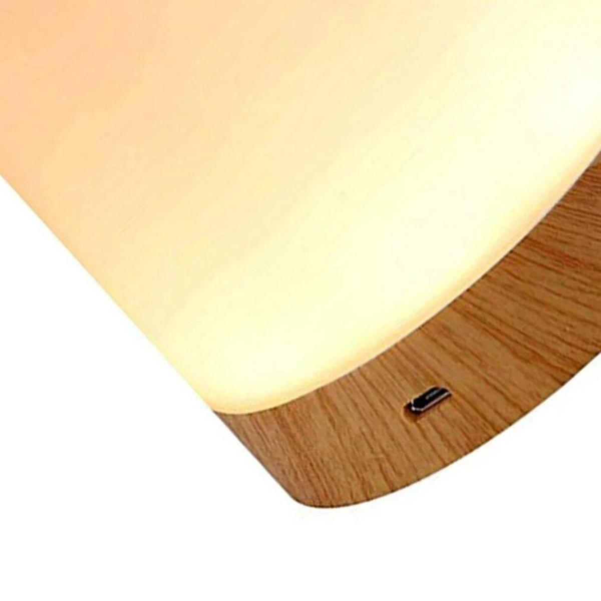 Nahaufnahme der Lampenoberseite: weißes Licht, das von einer Lampe auf Holzbasis mit Ladeanschluss ausgeht.